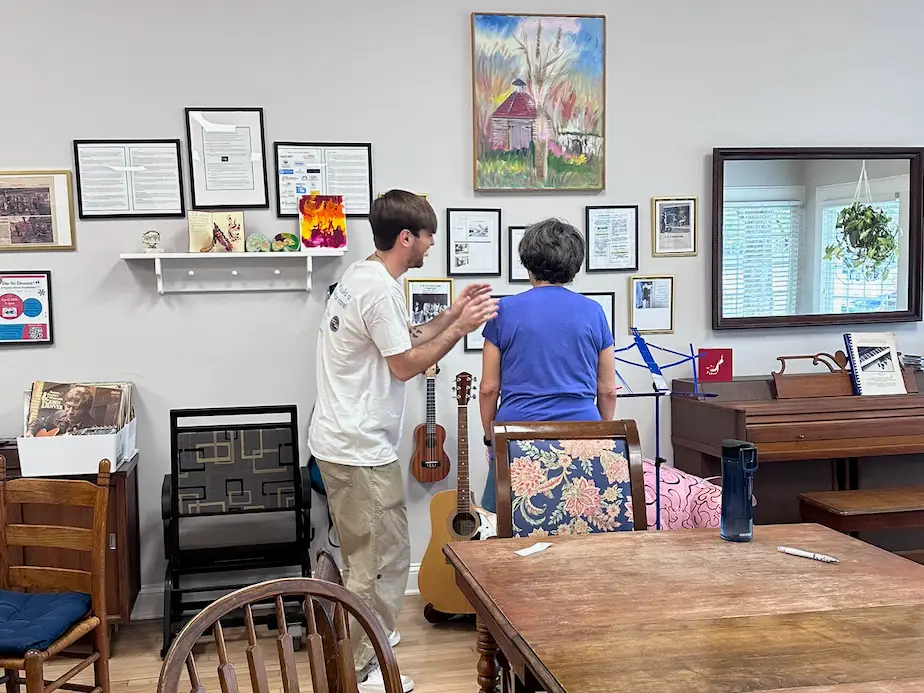 A young man looking at pictures with an older, adult woman.