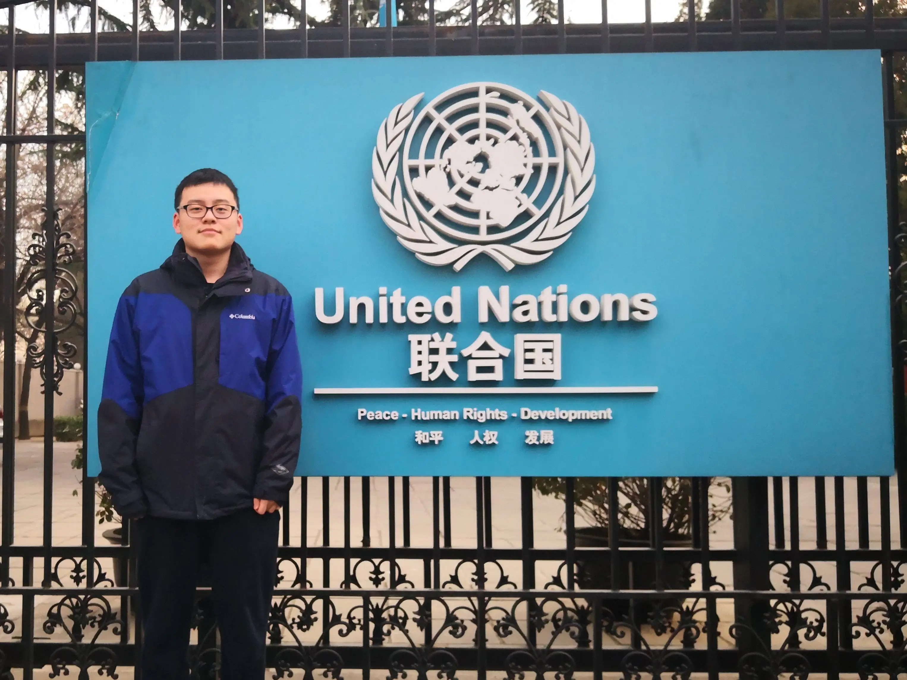A man standing outside of the United Nations building in China.