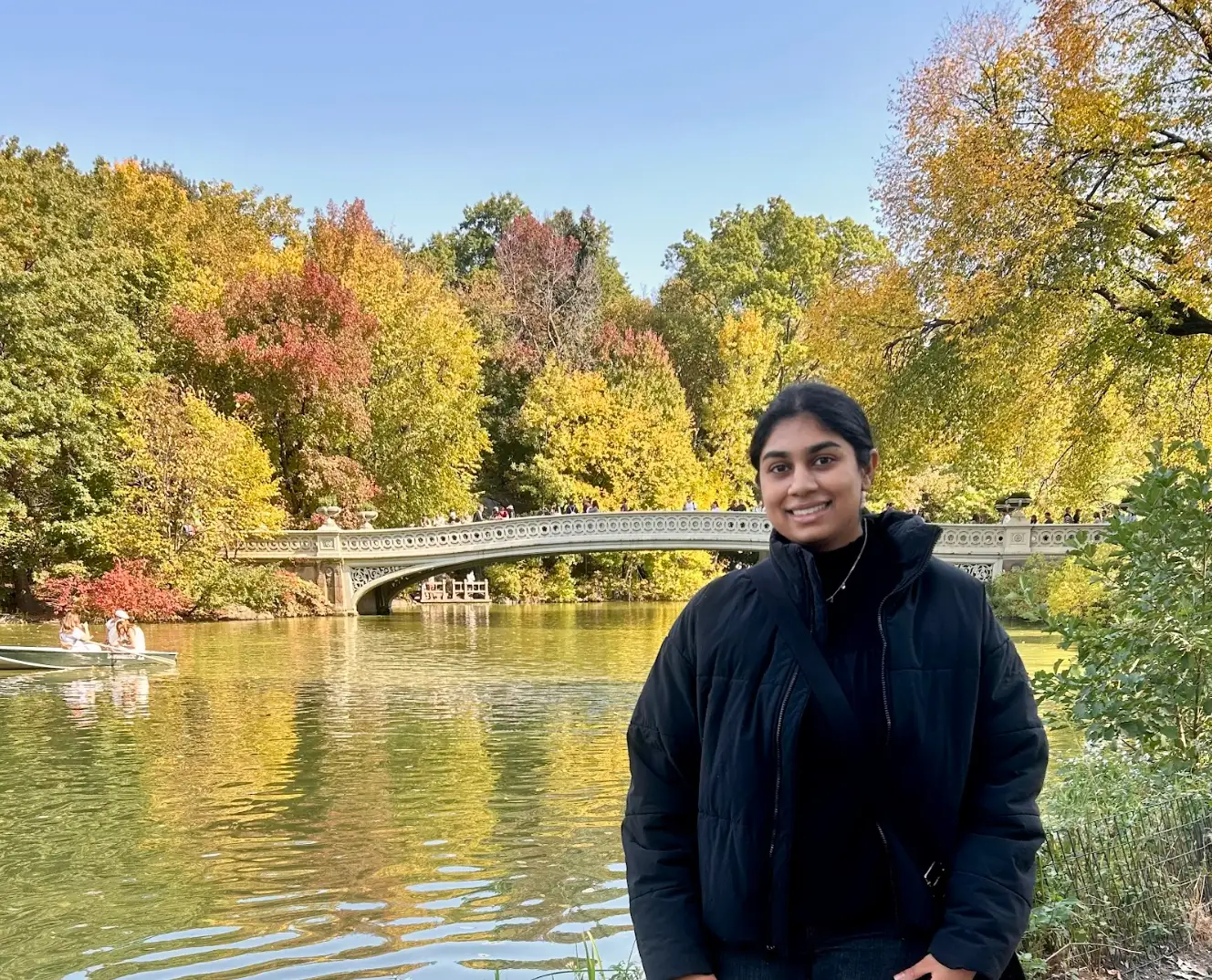 The writer standing in Central Park, with fall foliage in the background.