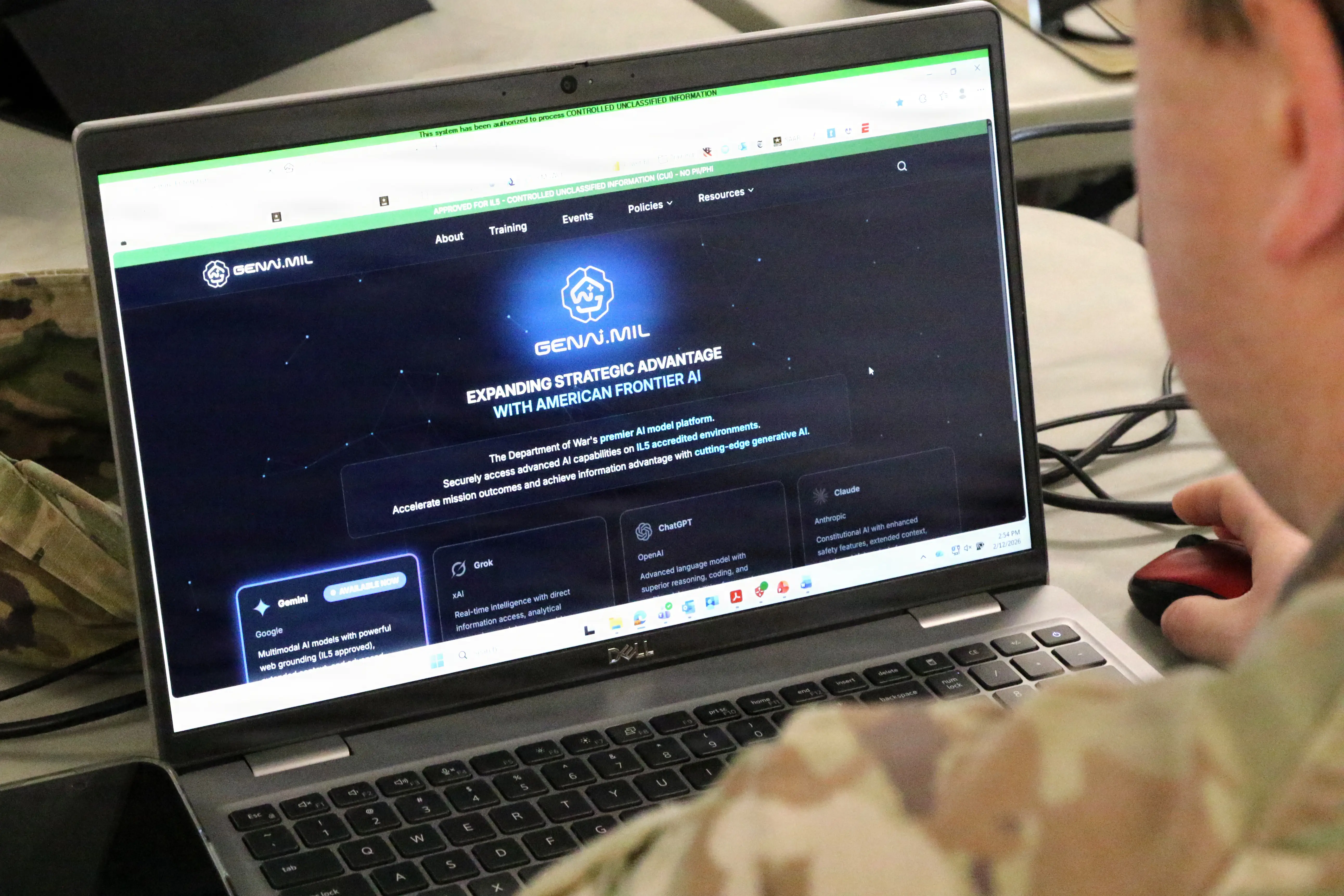 A laptop screen shows GenAI.mil, a US military AI program.