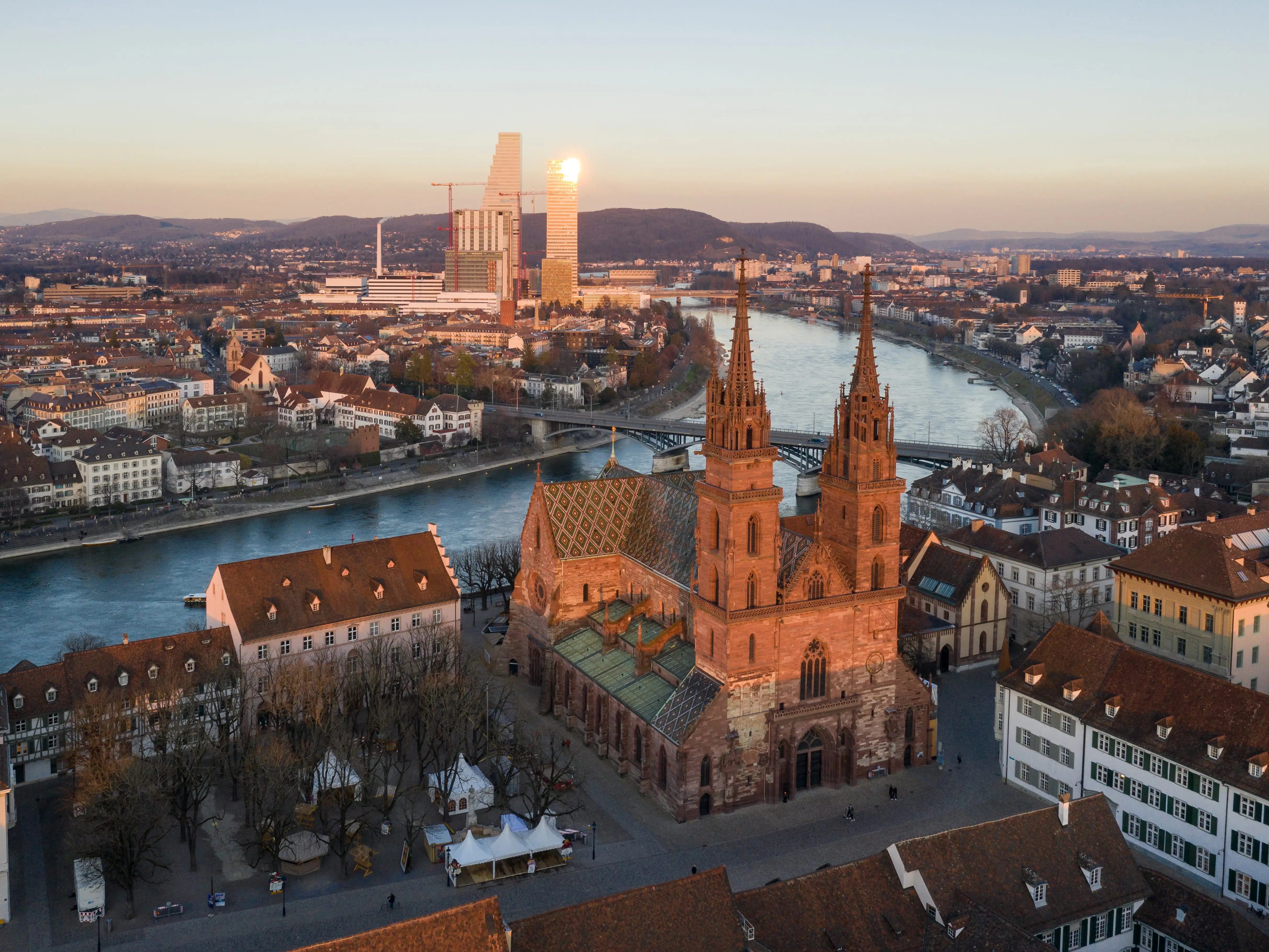 Aerial view of the Basel medieval old town with its cathedral along the Rhine river with modern officel buildings in the background, in Switzerland