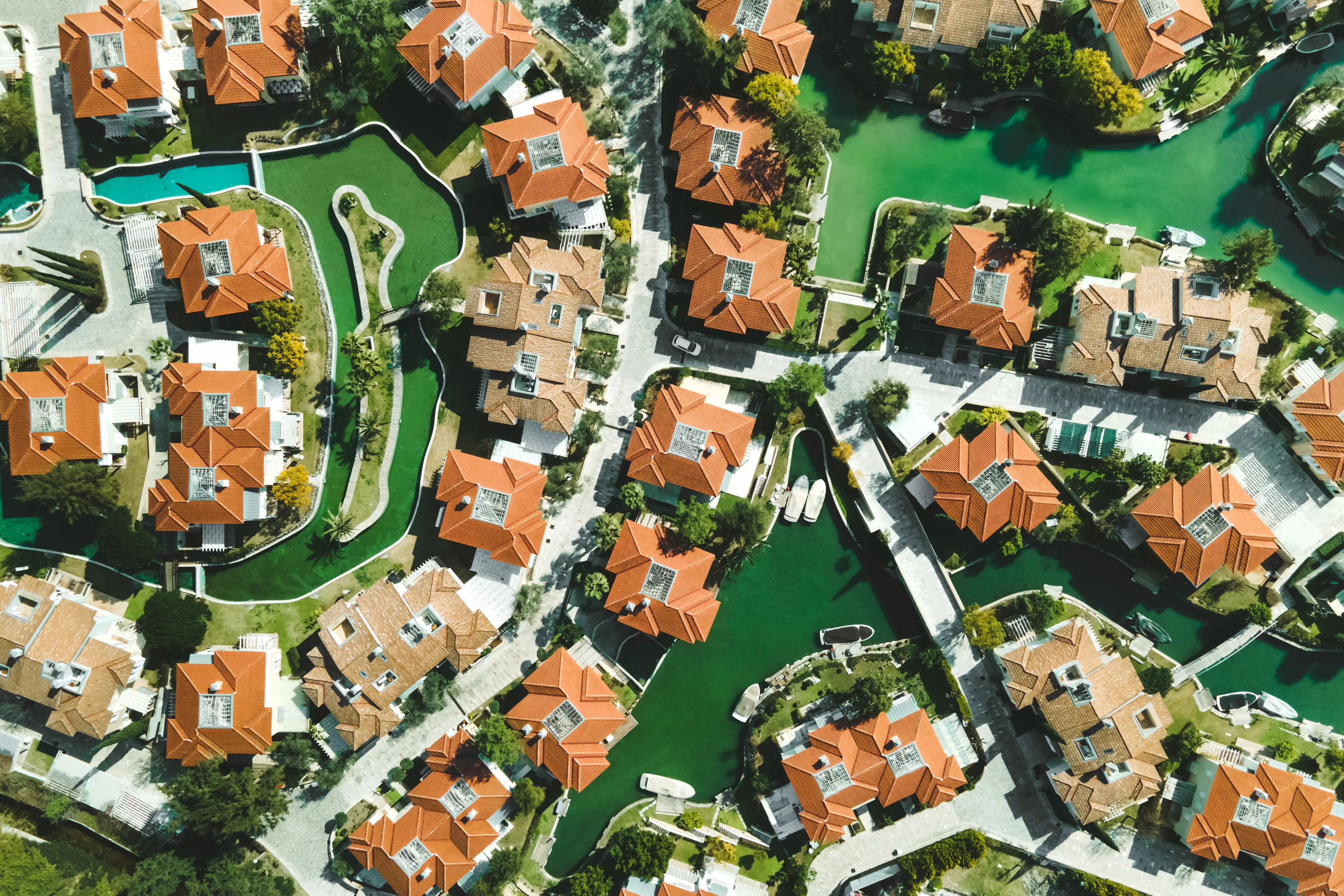 An aerial view of a neighborhood where homes sit next to water.