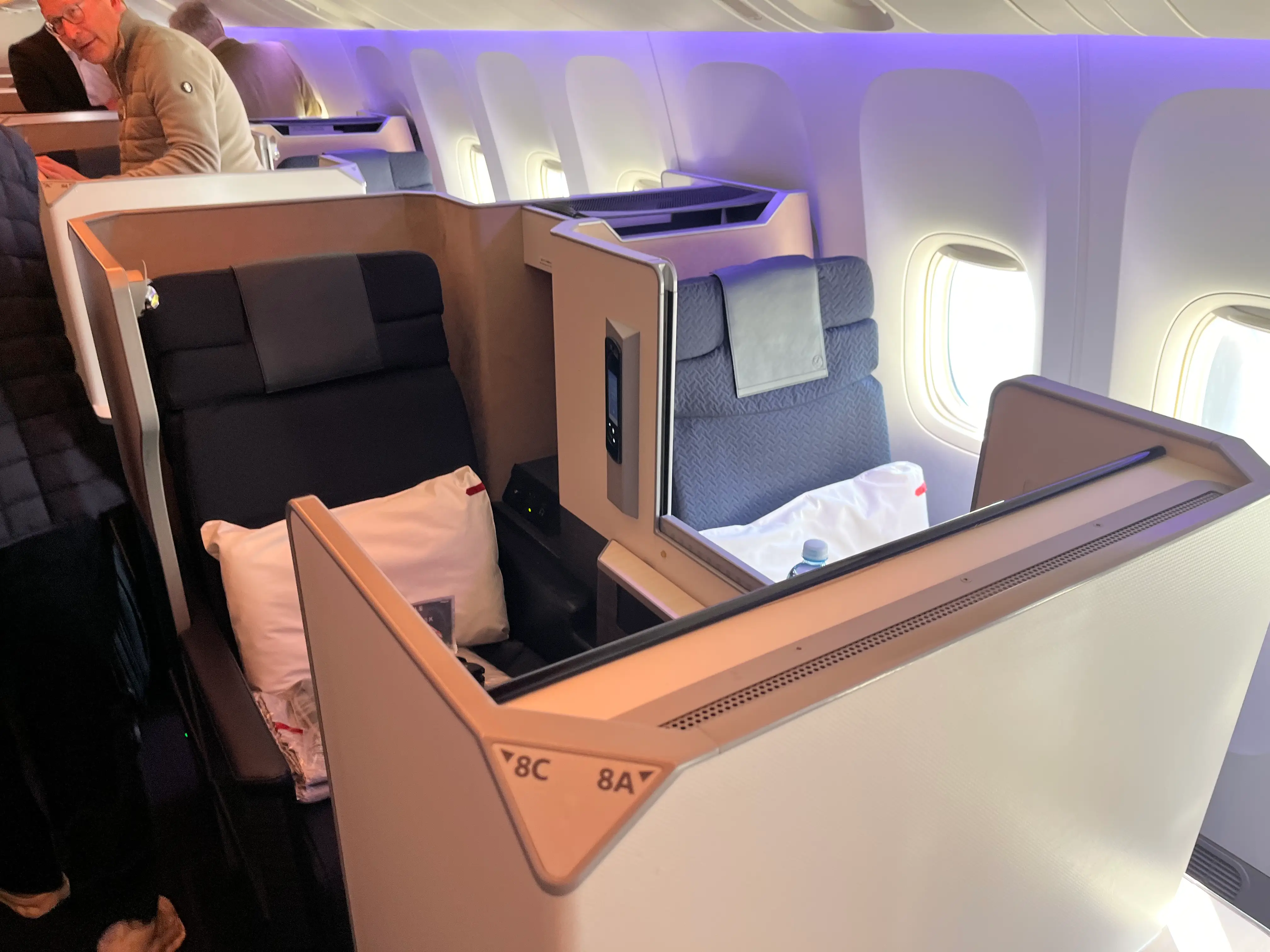 Business class seats next to each other on Japan Airlines flight with divder that goes up and down