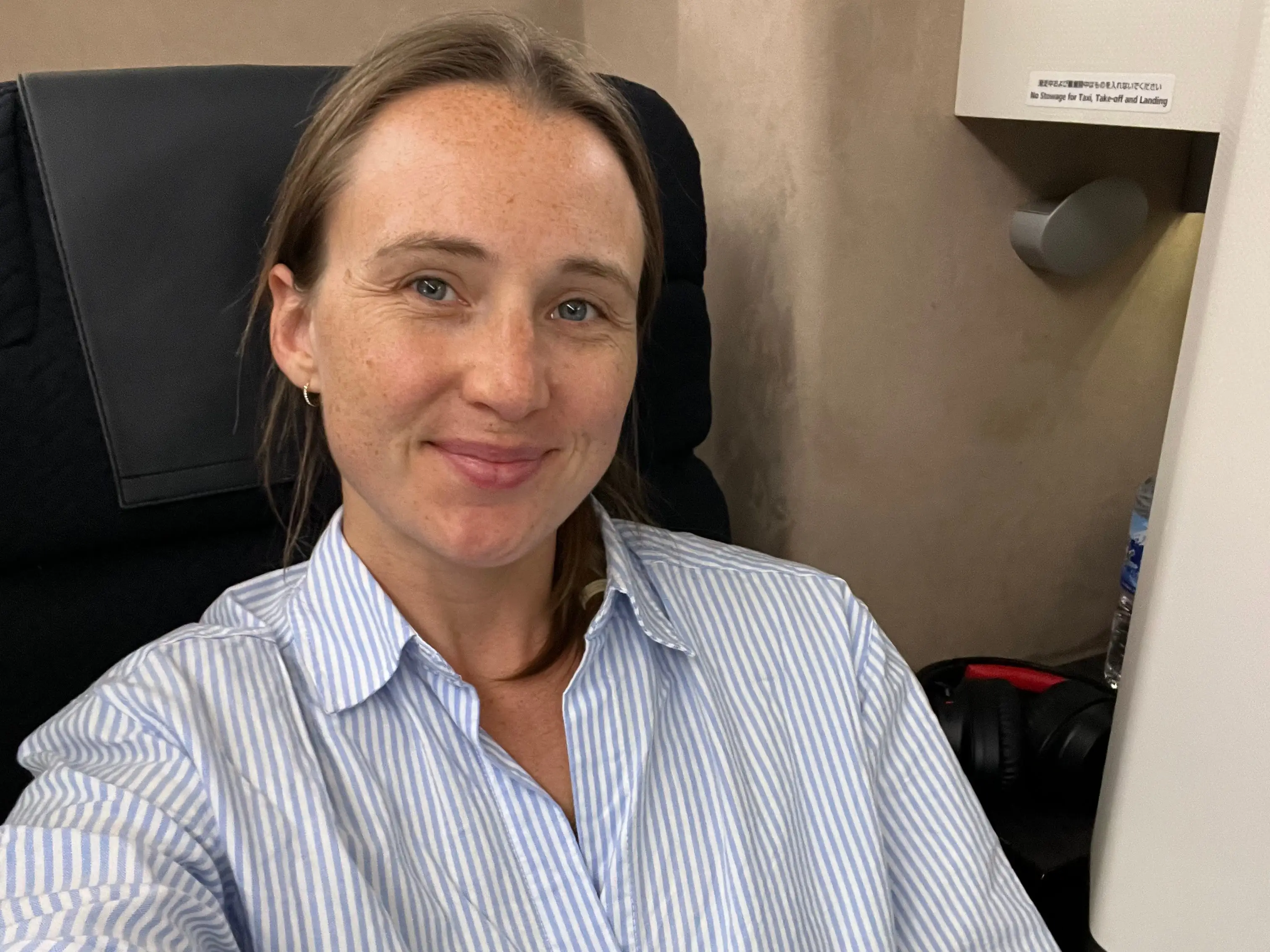 Woman smiling in Japan Air business-class seat