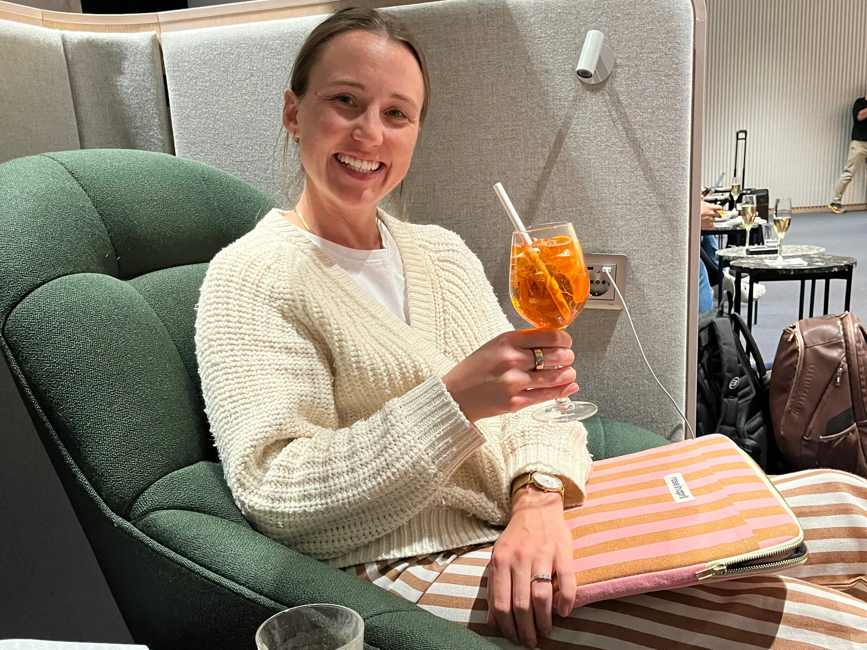 Woman sitting in lounge holding spritz