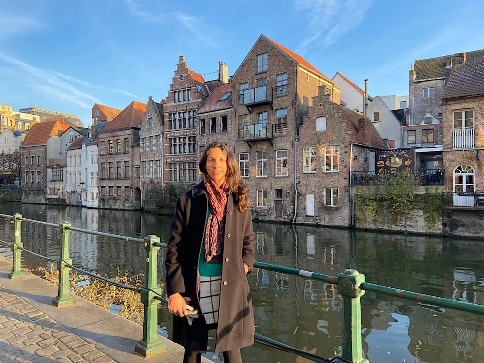 The author poses by a river in Belgium.