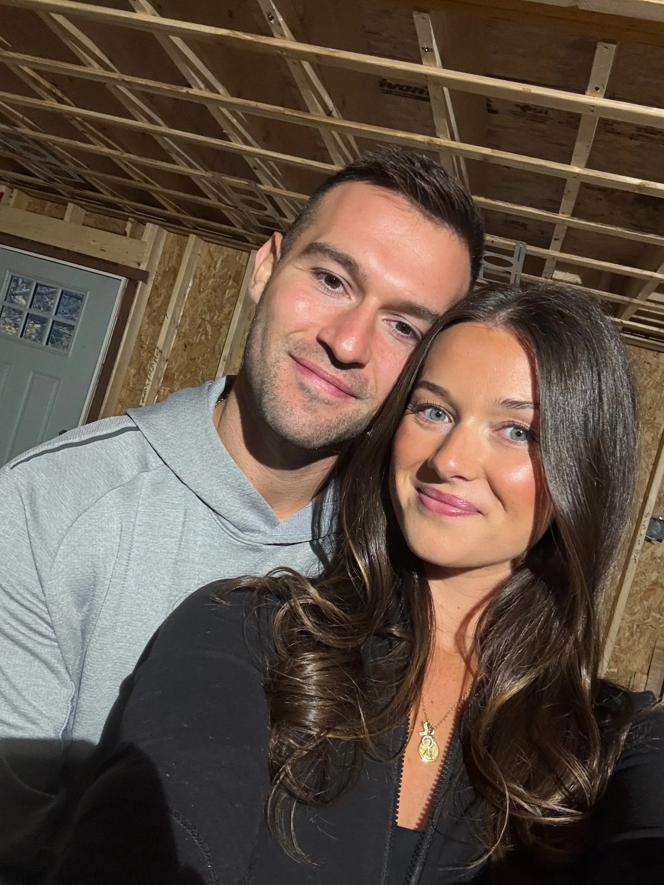 A selfie of a couple in a house under construction.