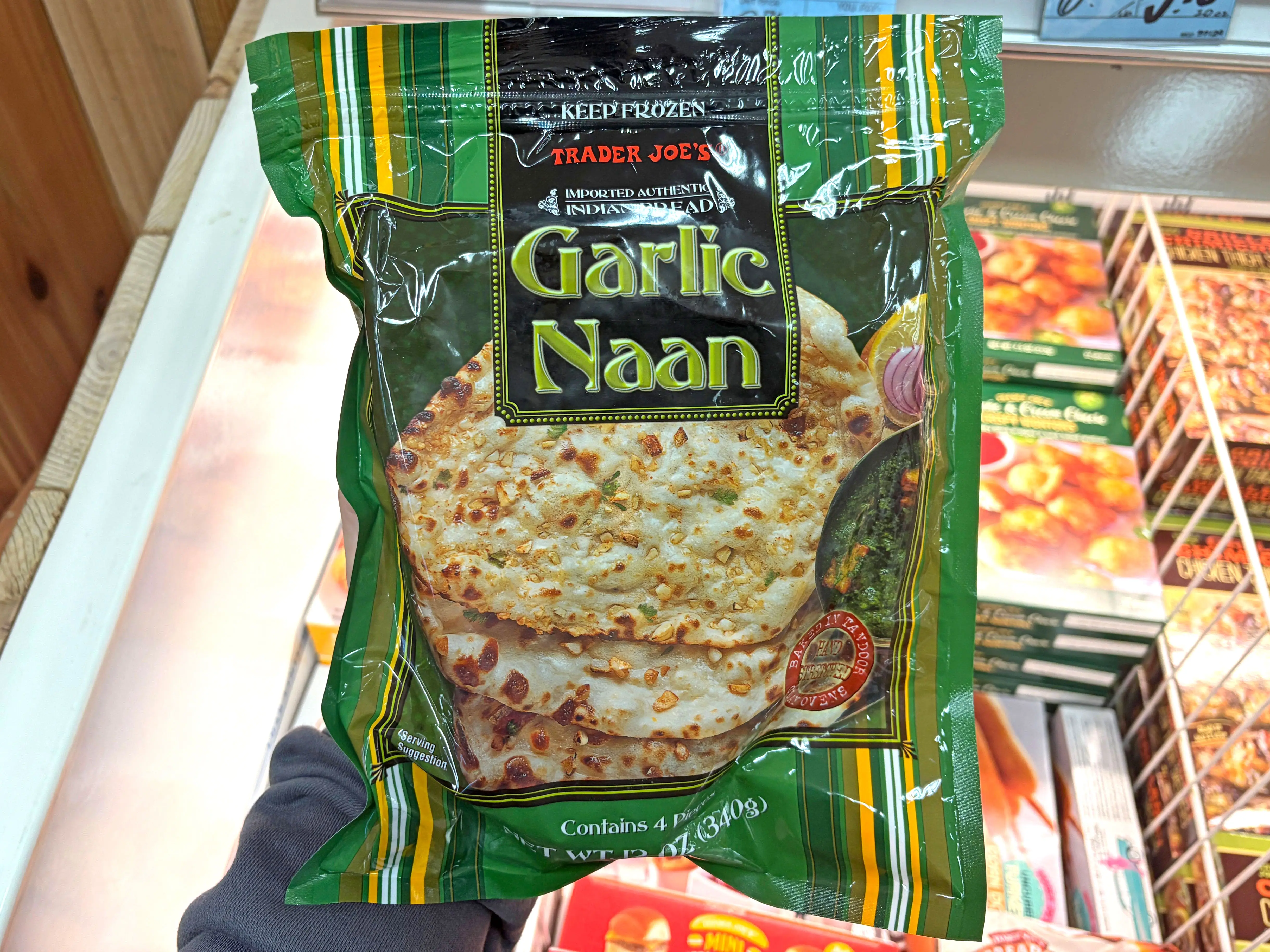 A hand holding a bag of Trader Joe's garlic naan.