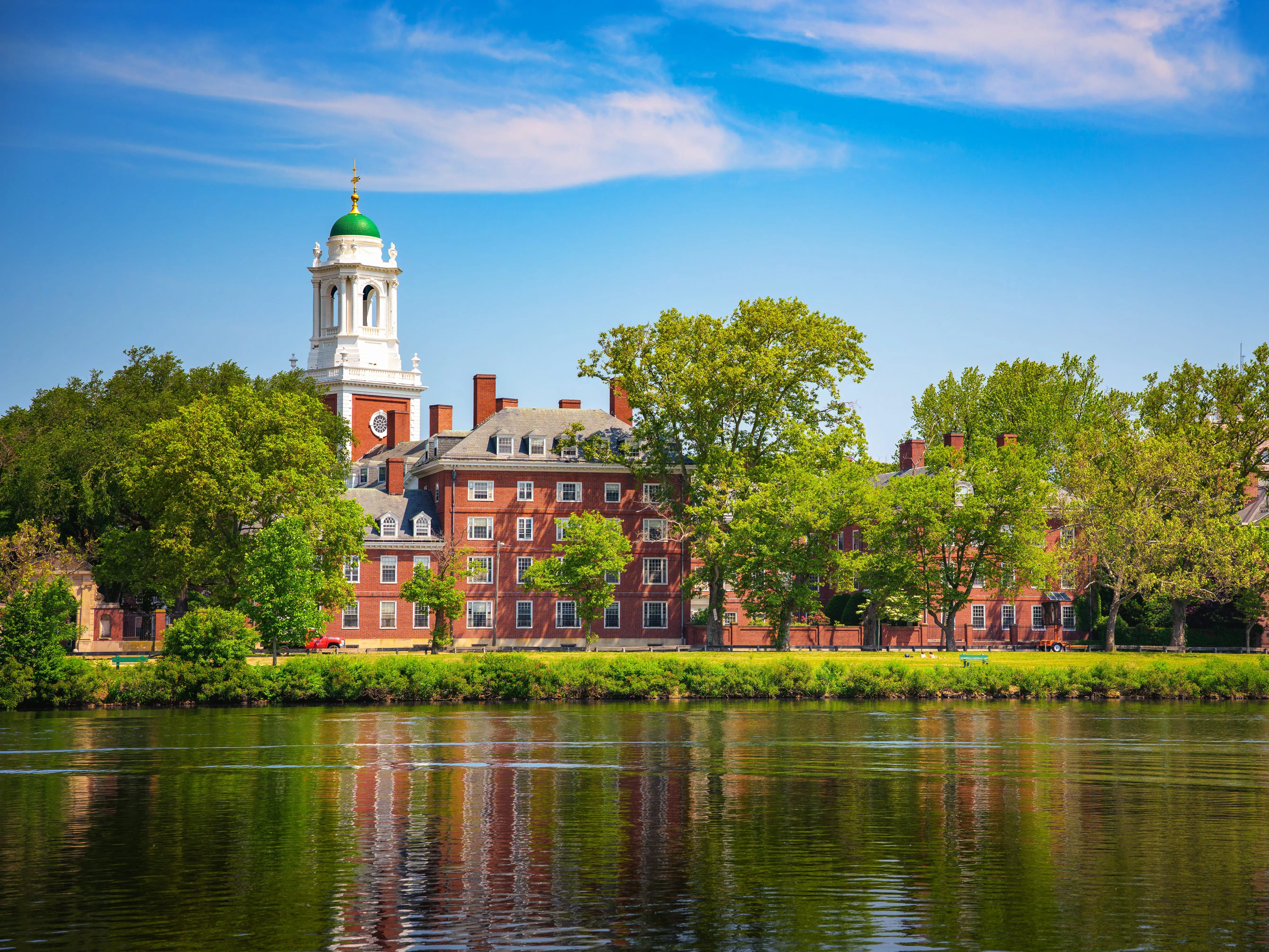 Cambridge, Massachusetts, USA - June 05, 2025 Harvard University Eliot House and tower viewed across the Charles River in Cambridge, Massachusetts