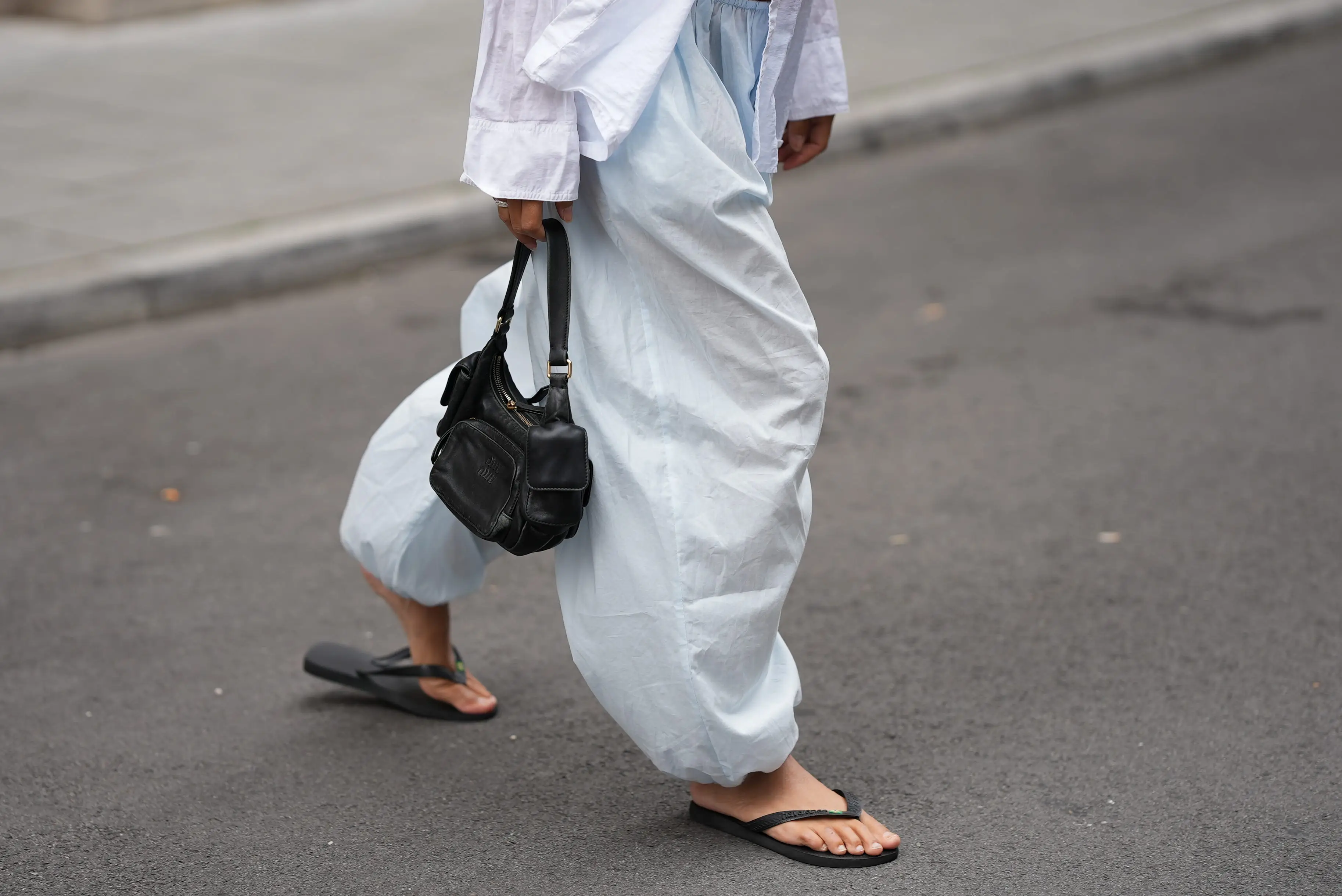 Person wearing baggy pants, black flip flops