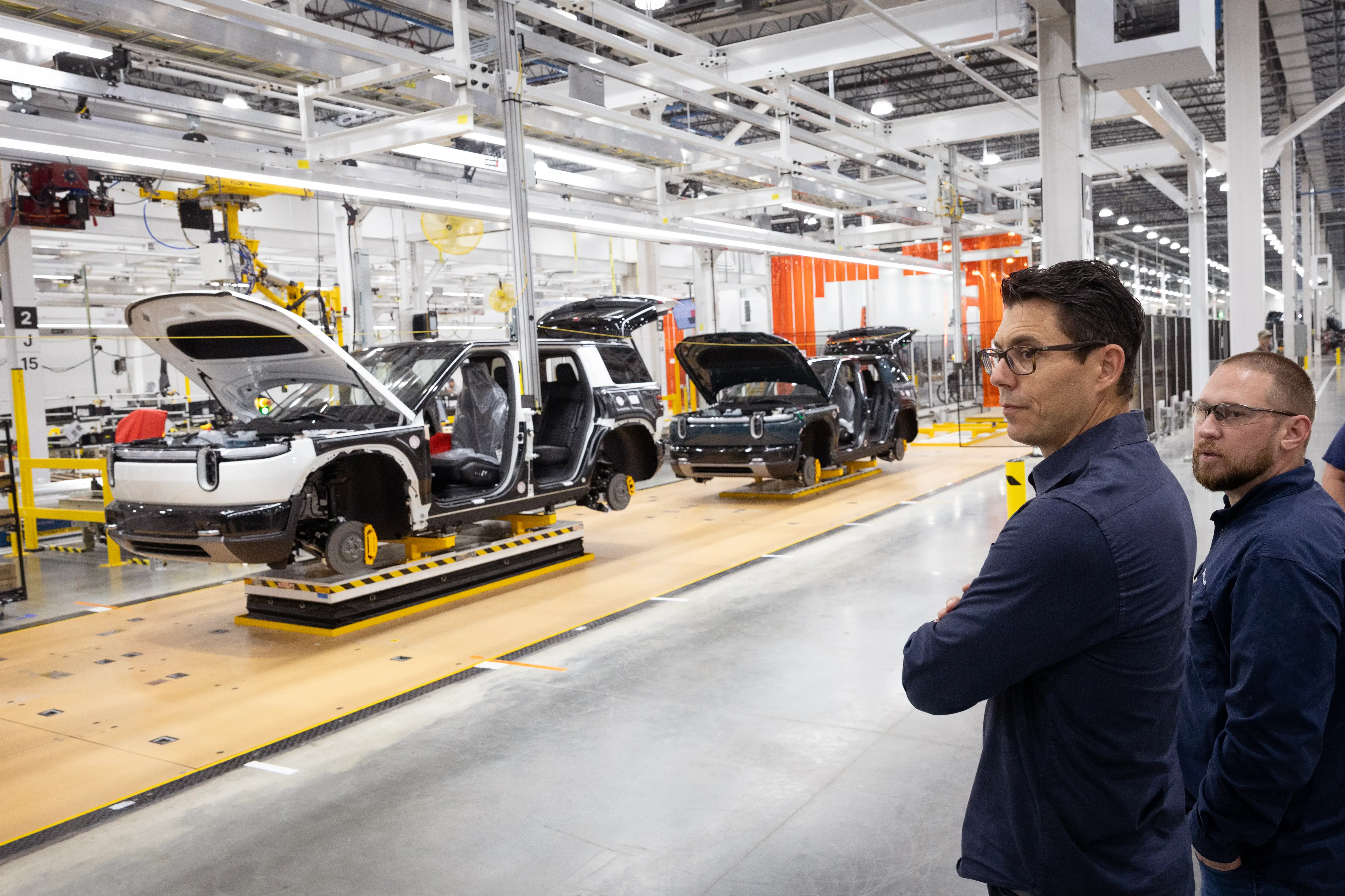 RJ Scaringe, Rivian's CEO, looks at the EV-maker's Illinois production line, where the midsize R2 is built.