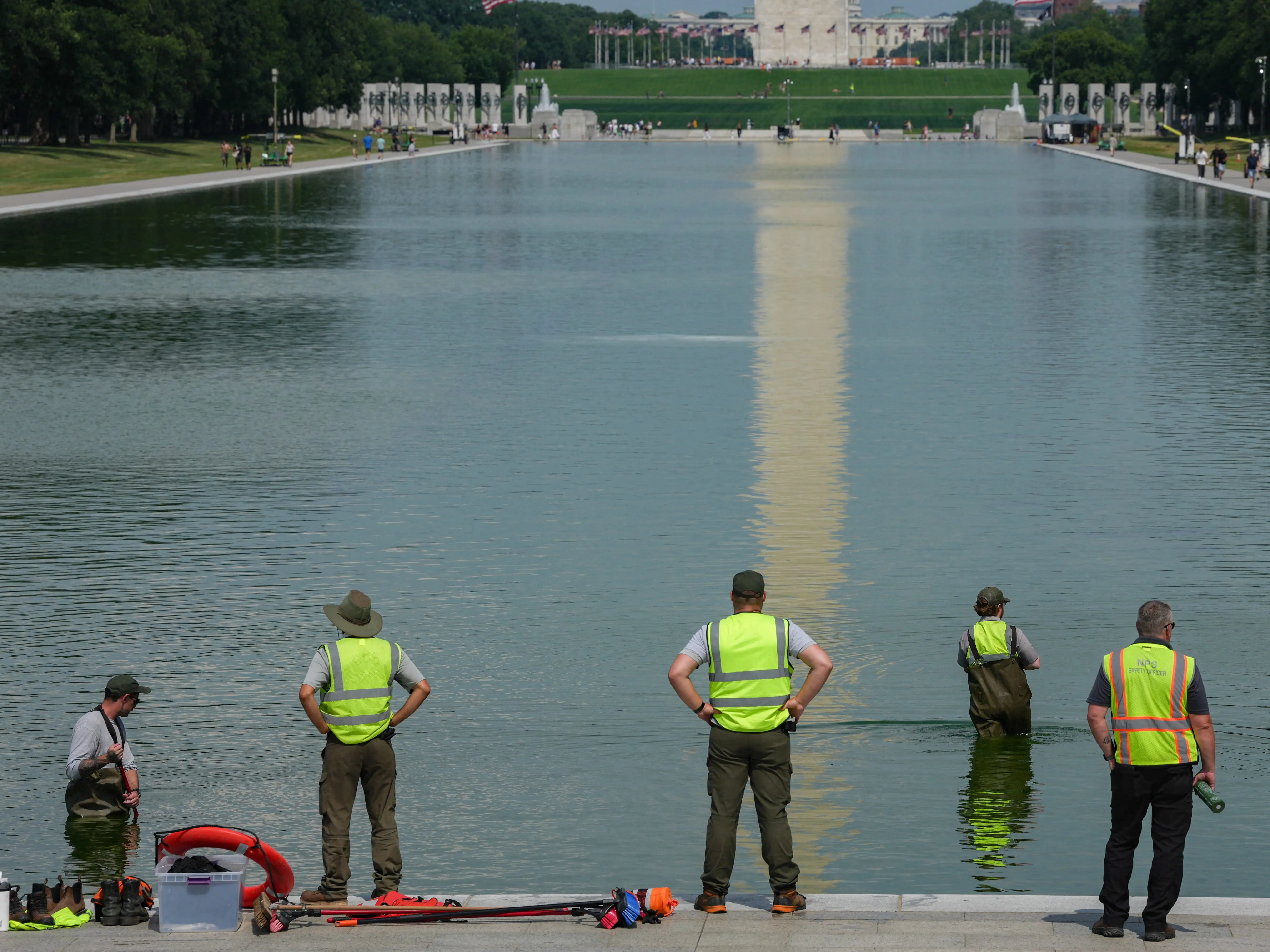 National Park Service workers push algae towards an aeration area in the center of the Lincoln Memorial Reflecting Pool following the completion of recent renovations in Washington, DC, on June 14, 2026