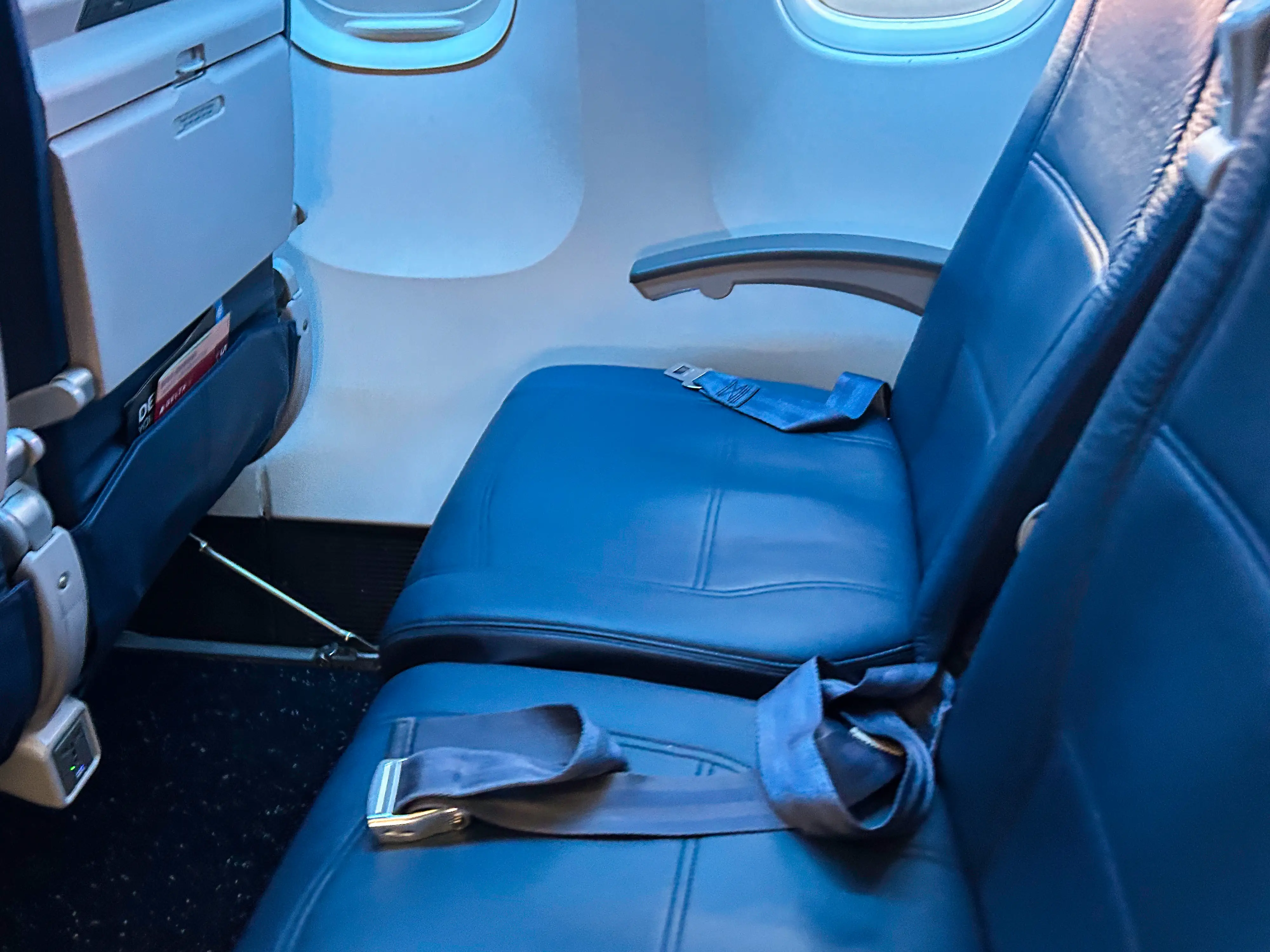 Two blue airplane seats in economy