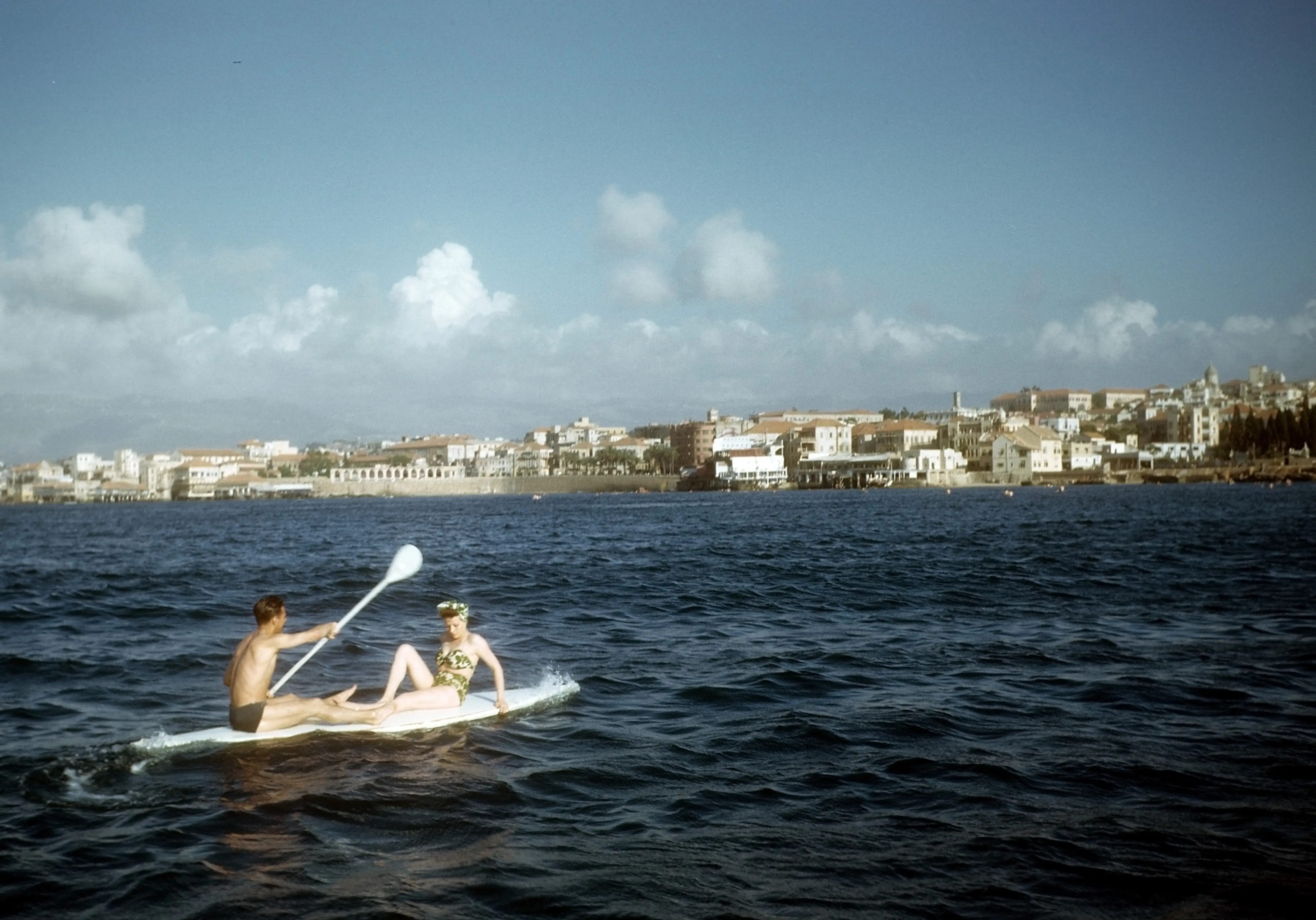 MAY 1948: A view of a young couple on a surf board paddling on the ocean in Beirut, Lebanon.