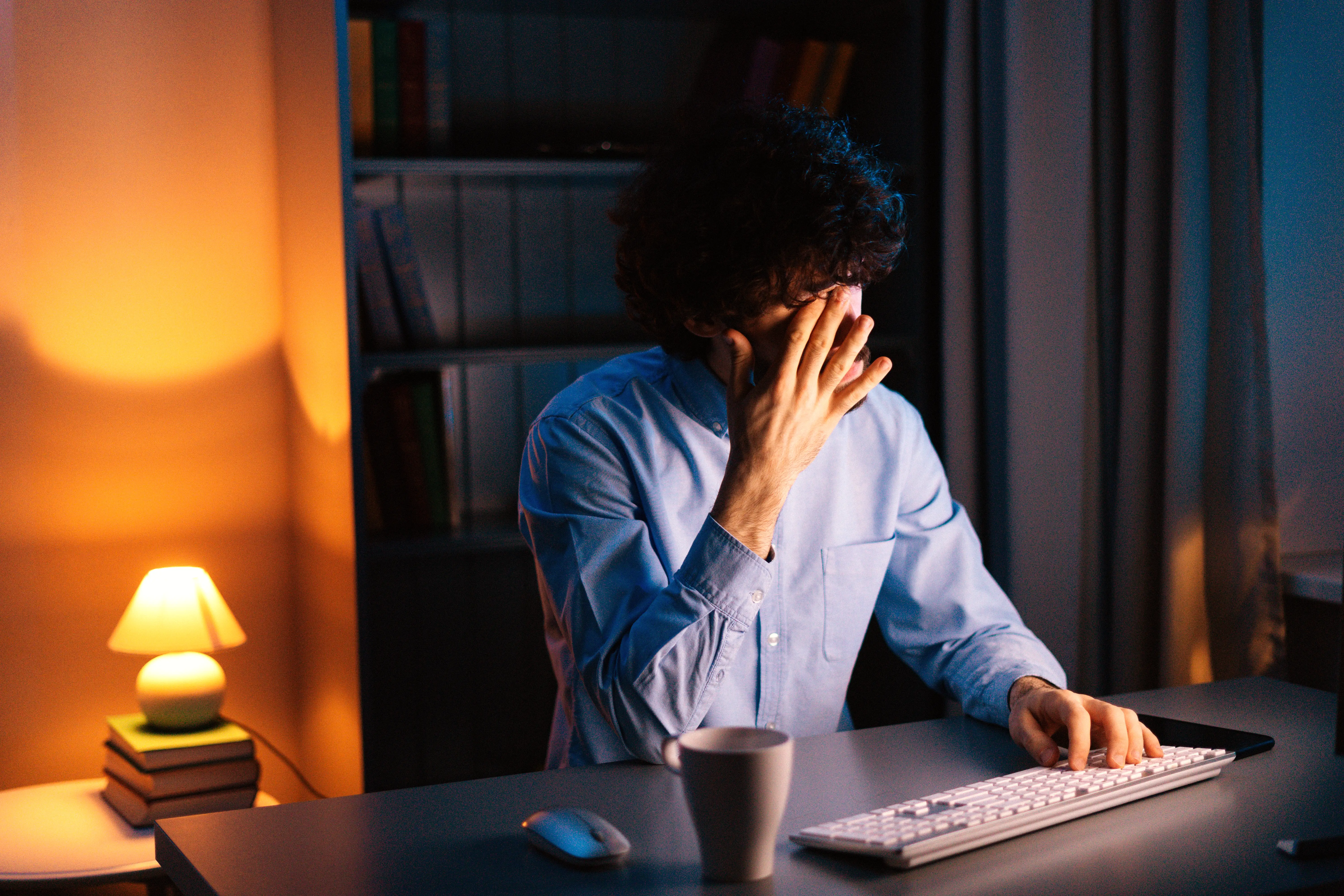 A man looking frustrated in front of a desktop computer