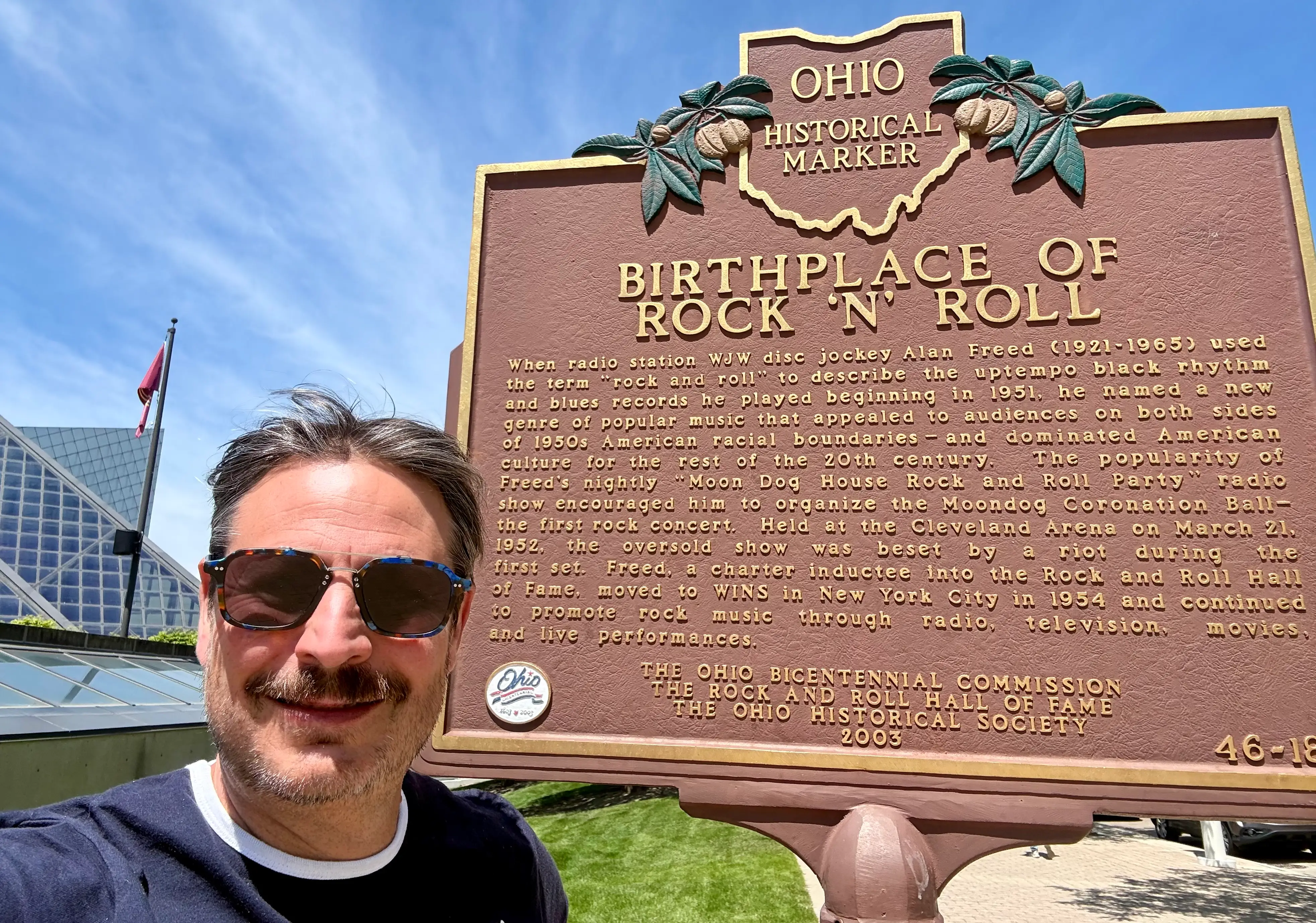 Man smiling with Ohio birthplace of rock and roll marker