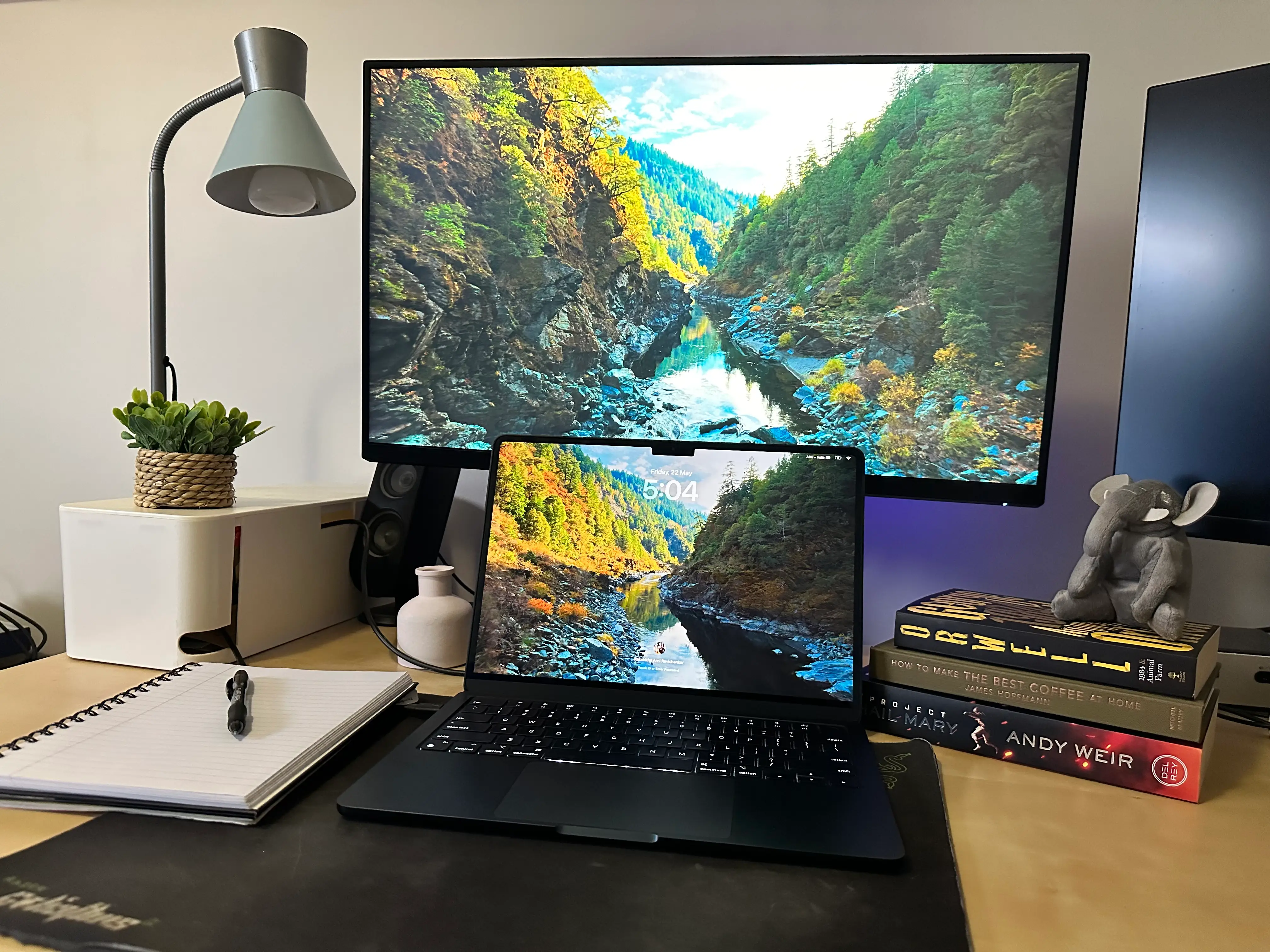 The writer's desk setup, with three books, two computer monitors, and a laptop.