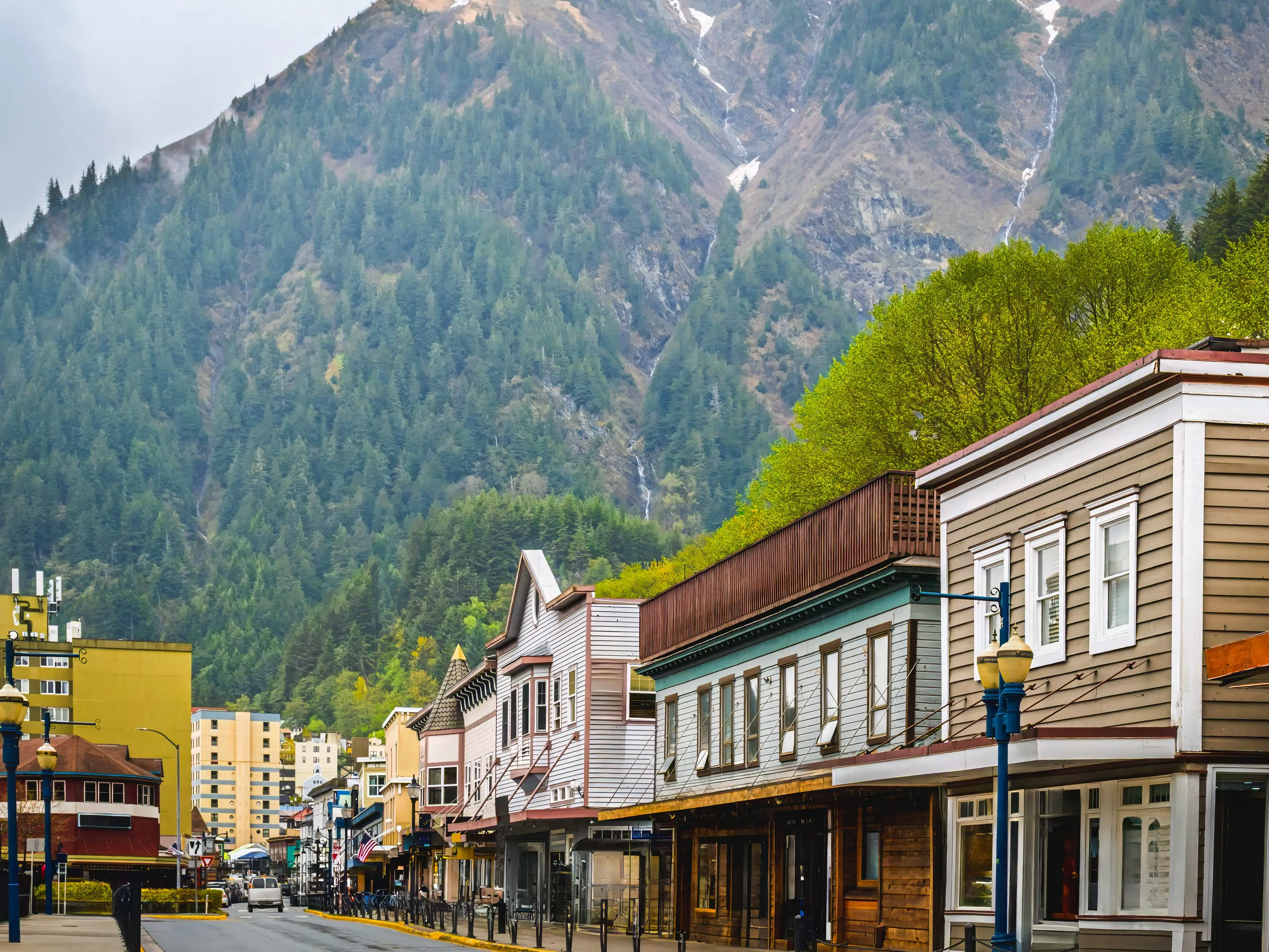 View of street in downtown Juneau, Alaska, on spring day; mountains in background
