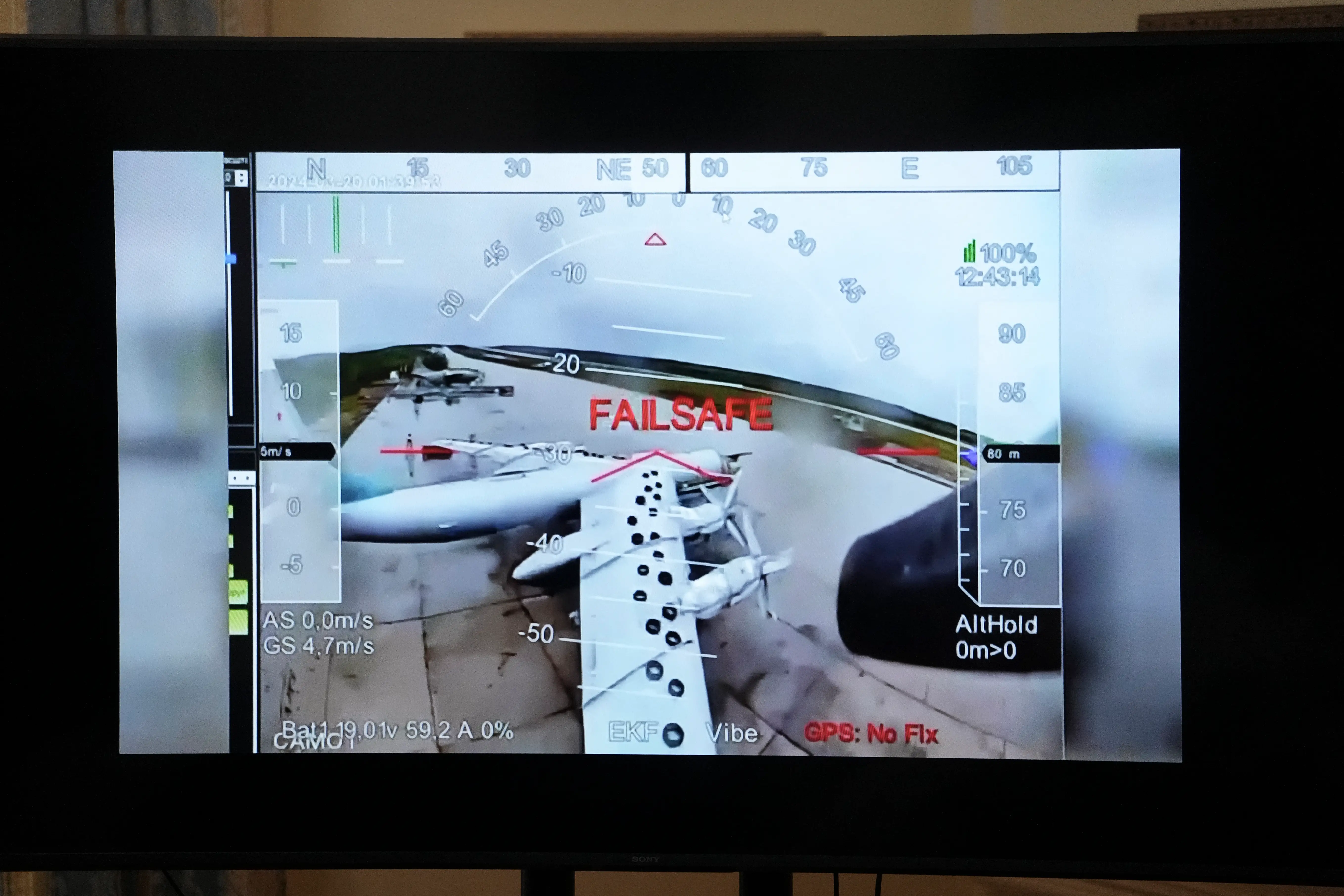 A television screen shows a drone's perspective as it targets an aircraft.