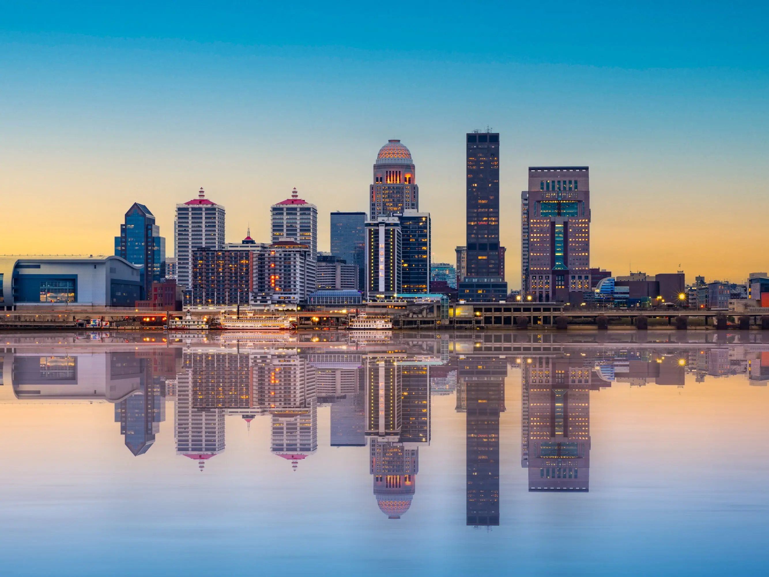Beautiful sunset night view of Louisville Kentucky Skyline with river and lit buildings