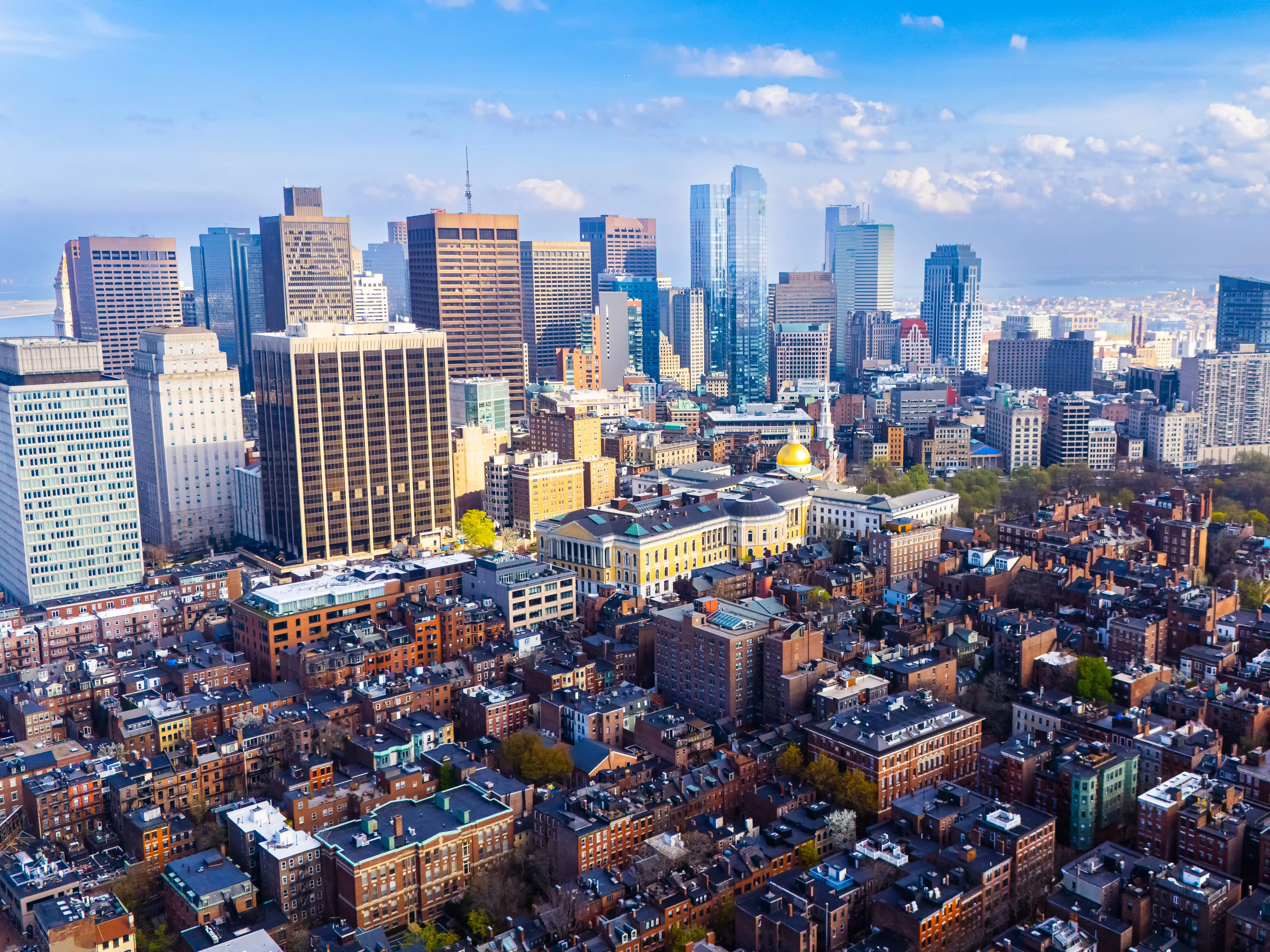 Orange brick houses along stunning skyscrapers. Varied scenery of Boston, Massachusetts, USA. Aerial view.