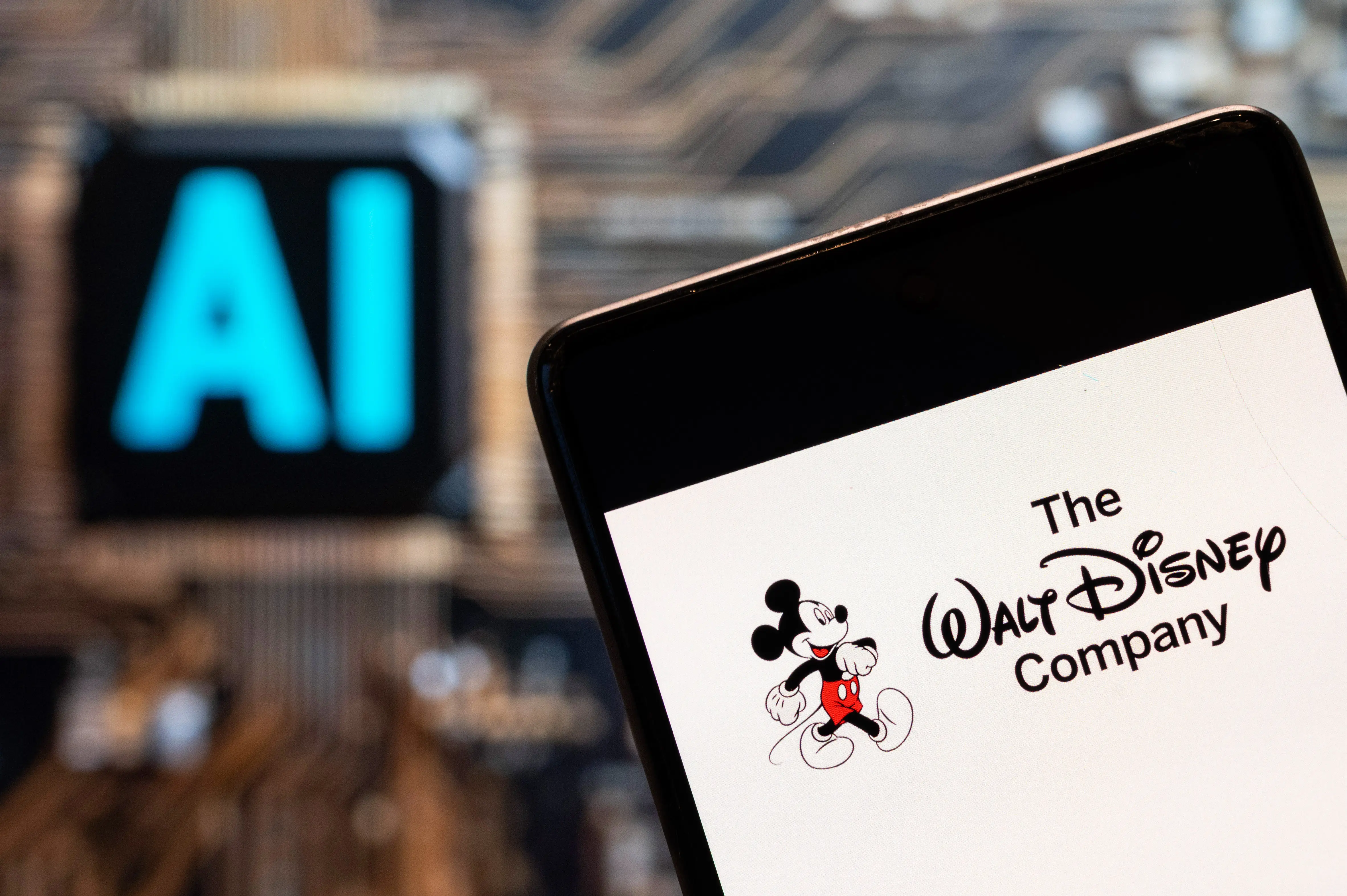 CHINA - 2023/11/03: In this photo illustration, the American multinational mass media and entertainment The Walt Disney Company or also called Disney logo seen displayed on a smartphone with an Artificial intelligence (AI) chip and symbol in the background. (Photo Illustration by Budrul Chukrut/SOPA Images/LightRocket via Getty Images)