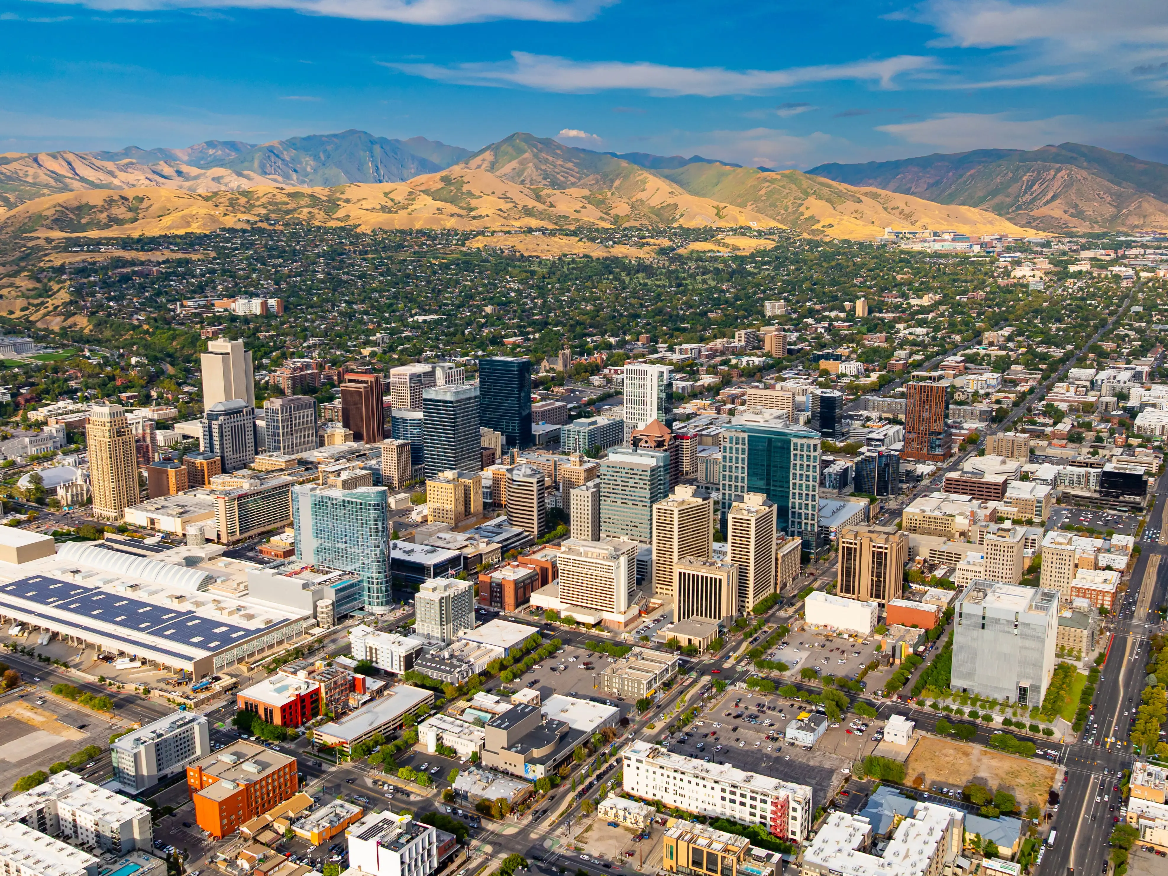 Downtown of Salt Lake City, Utah, USA. Green residential area scattered at backdrop at the foot of the mountains.