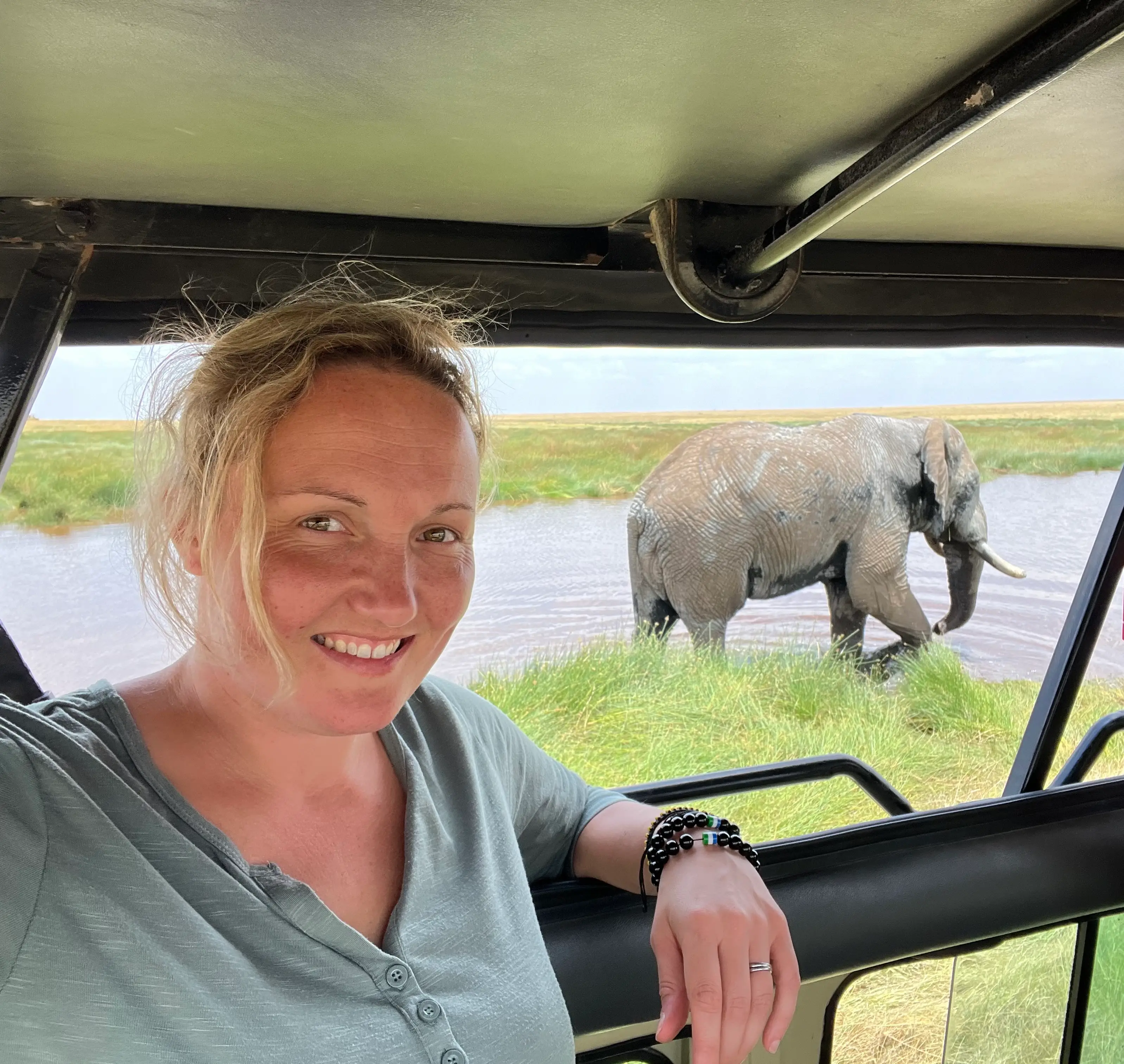 The author on a safari vehicle in africa with an elephant in the background.