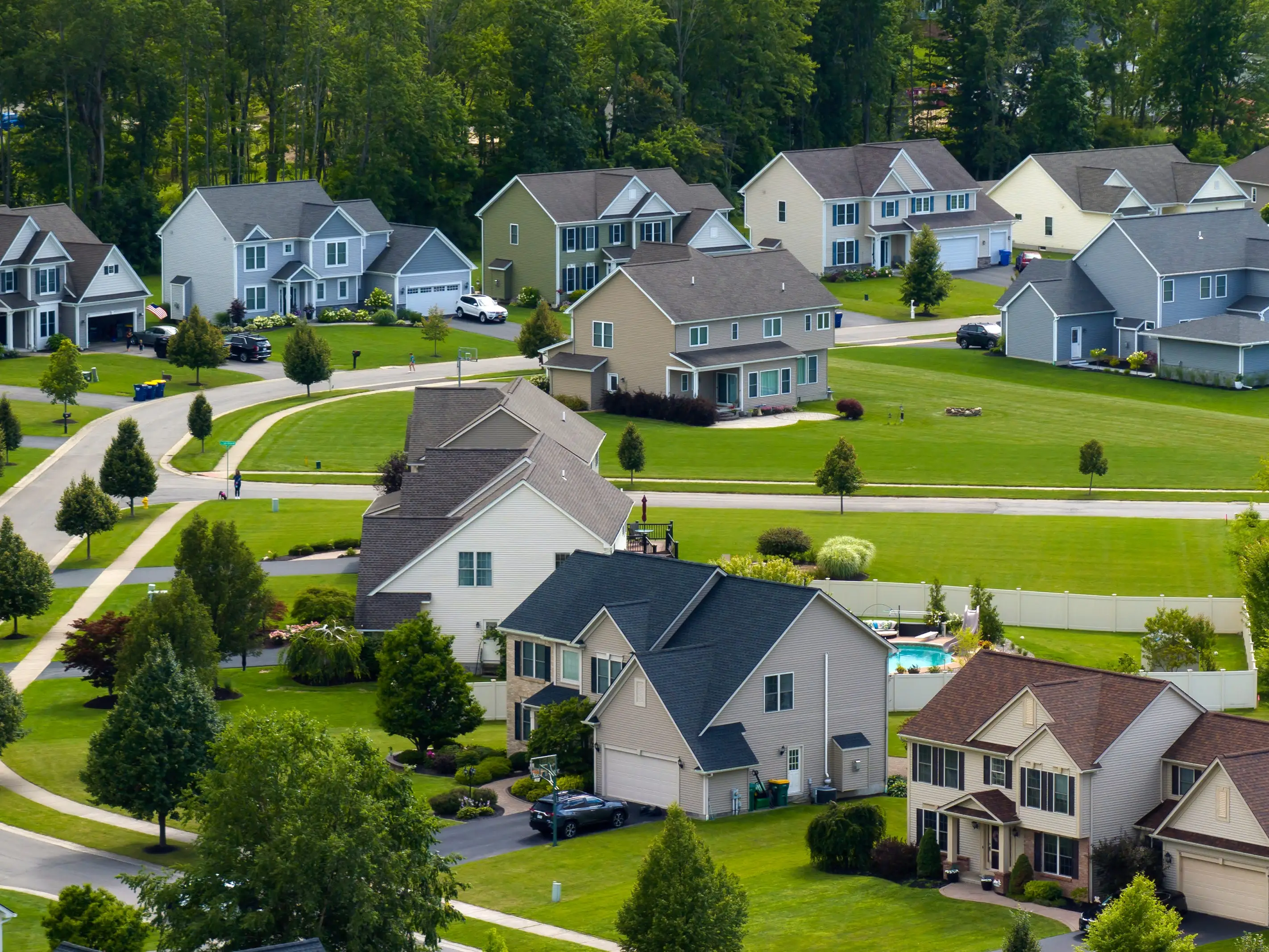Low-density two story private homes in rural residential suburbs outside of Rochester, New York. Upscale suburban houses with large lot size and green grassy lawns in summer season stock photo