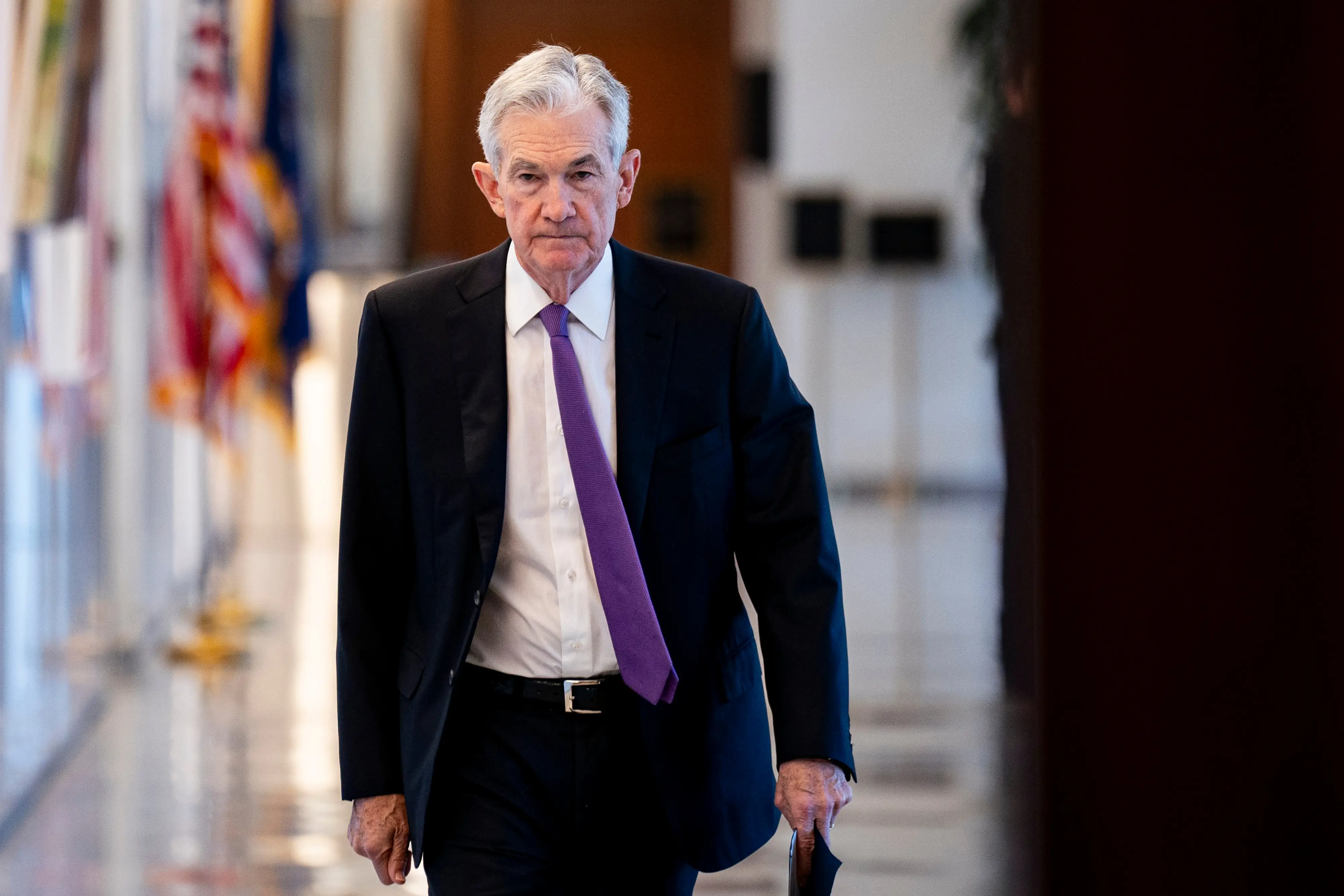 Jerome Powell, former chairman of the US Federal Reserve, walks down a hallway.