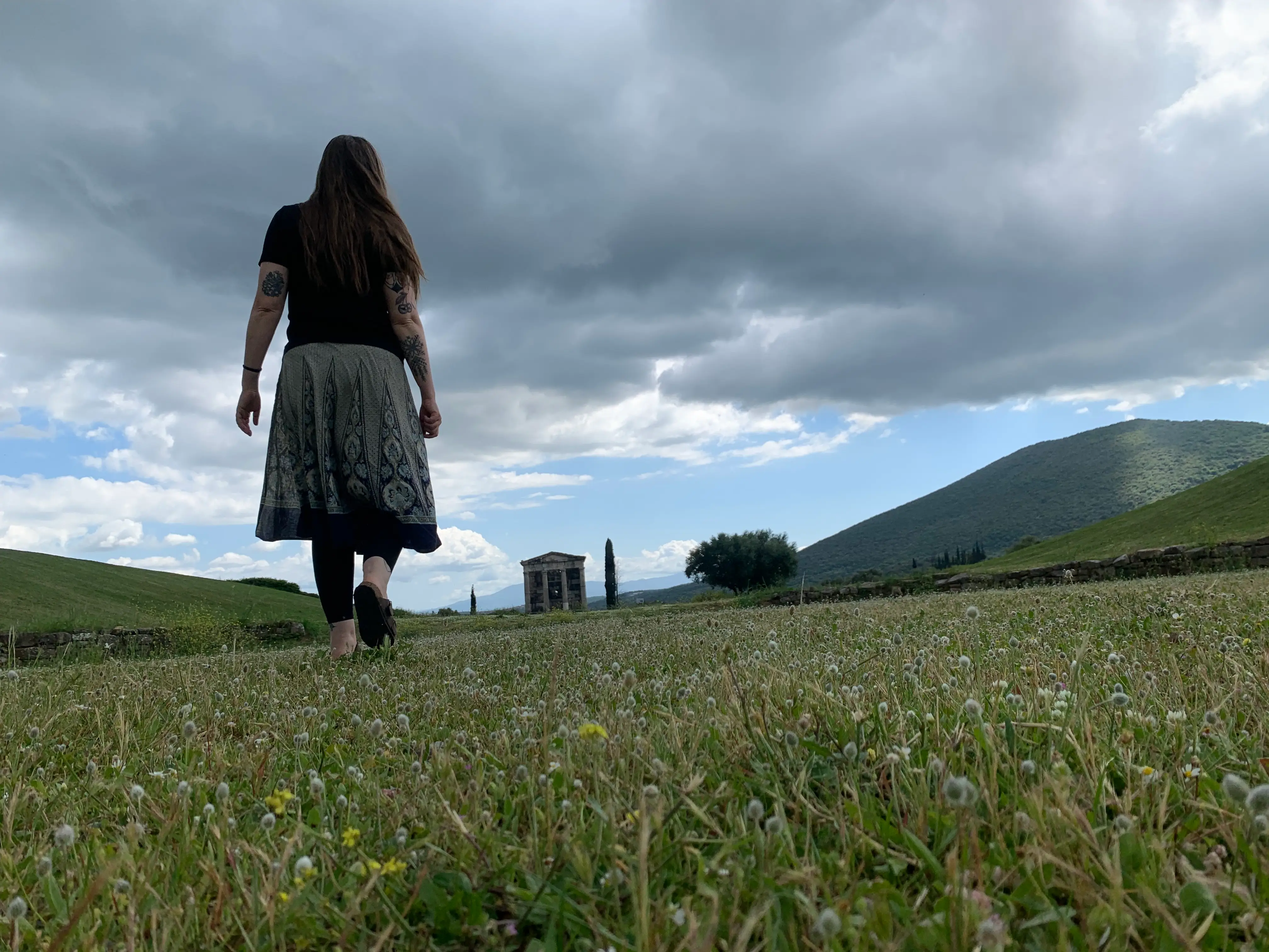 Woman in grass walking away from camera