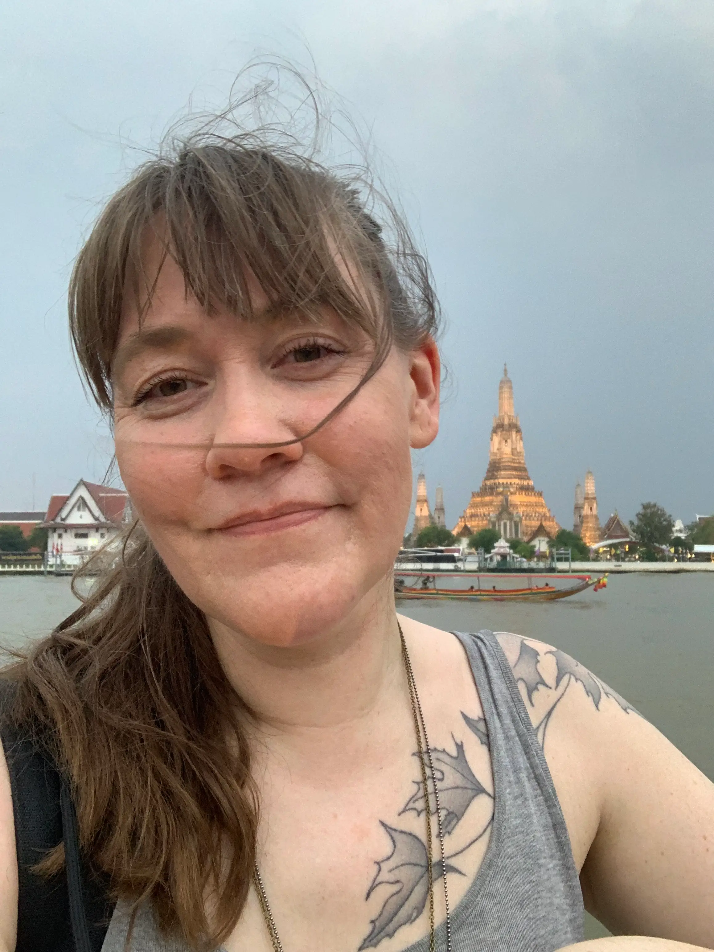 Woman smiling by Wat Arun in Bangkokg