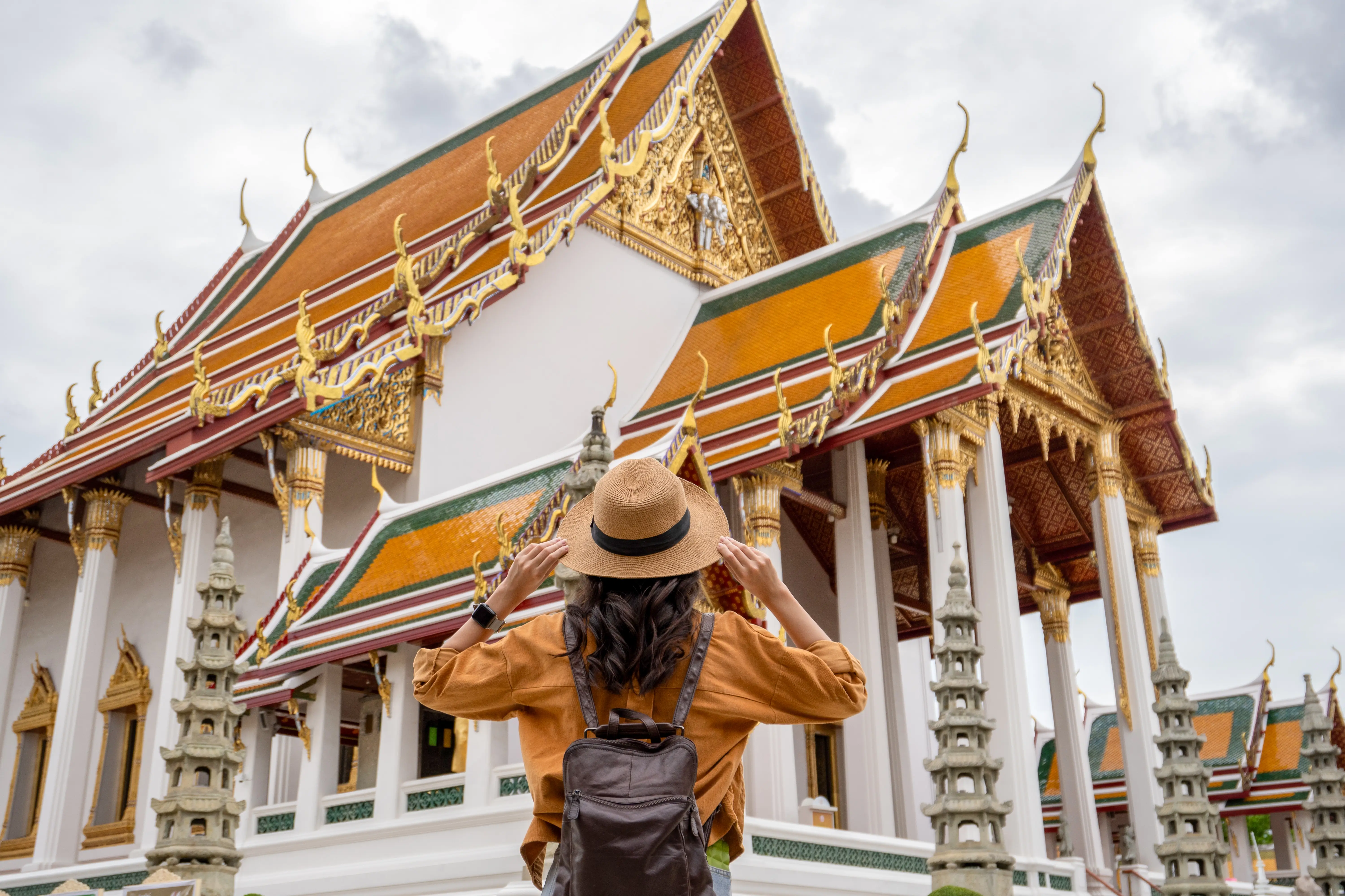 Back of woman in hat at temple in Thailand