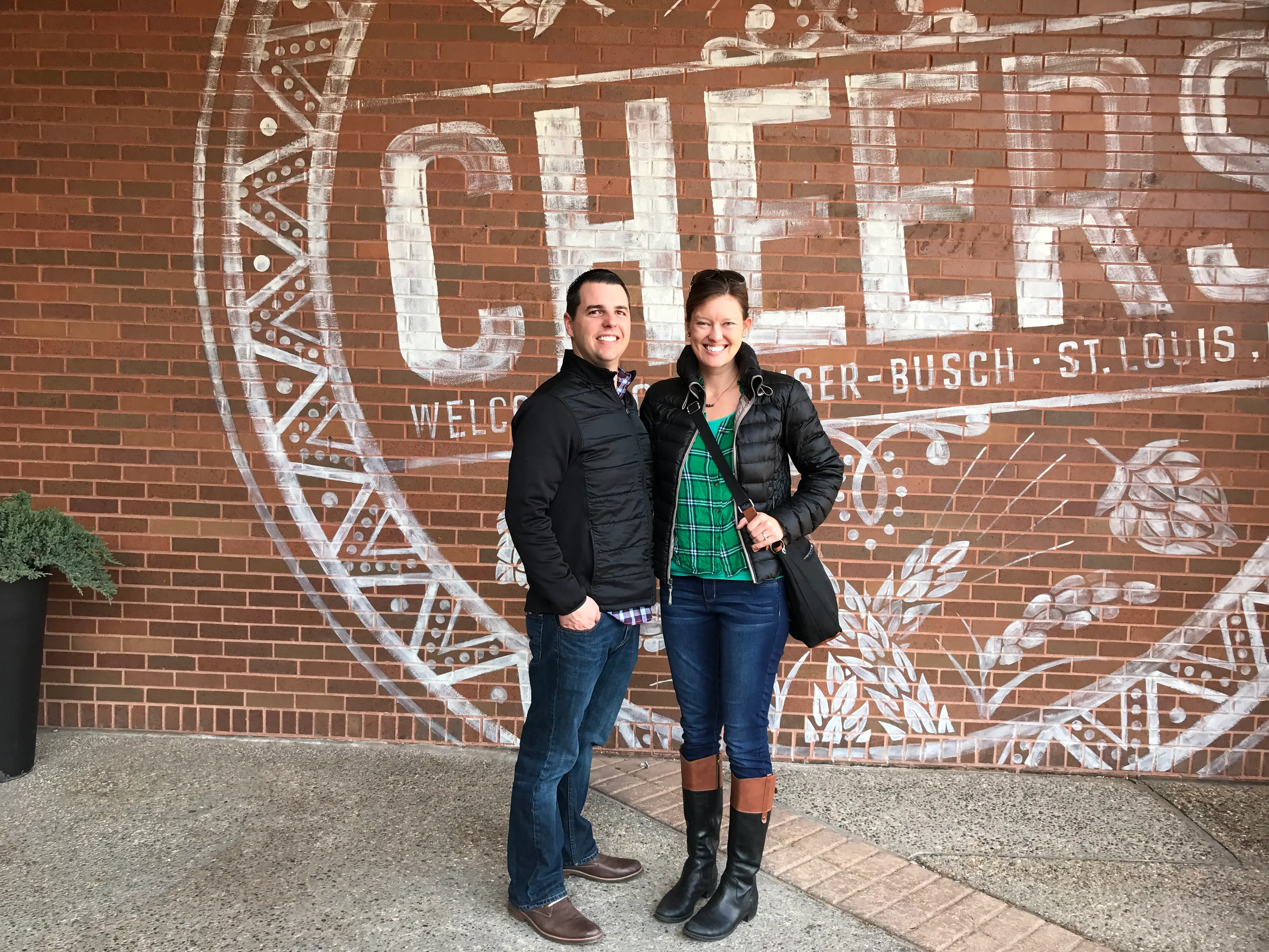 The author and her husband pose in front of a mural that reads 