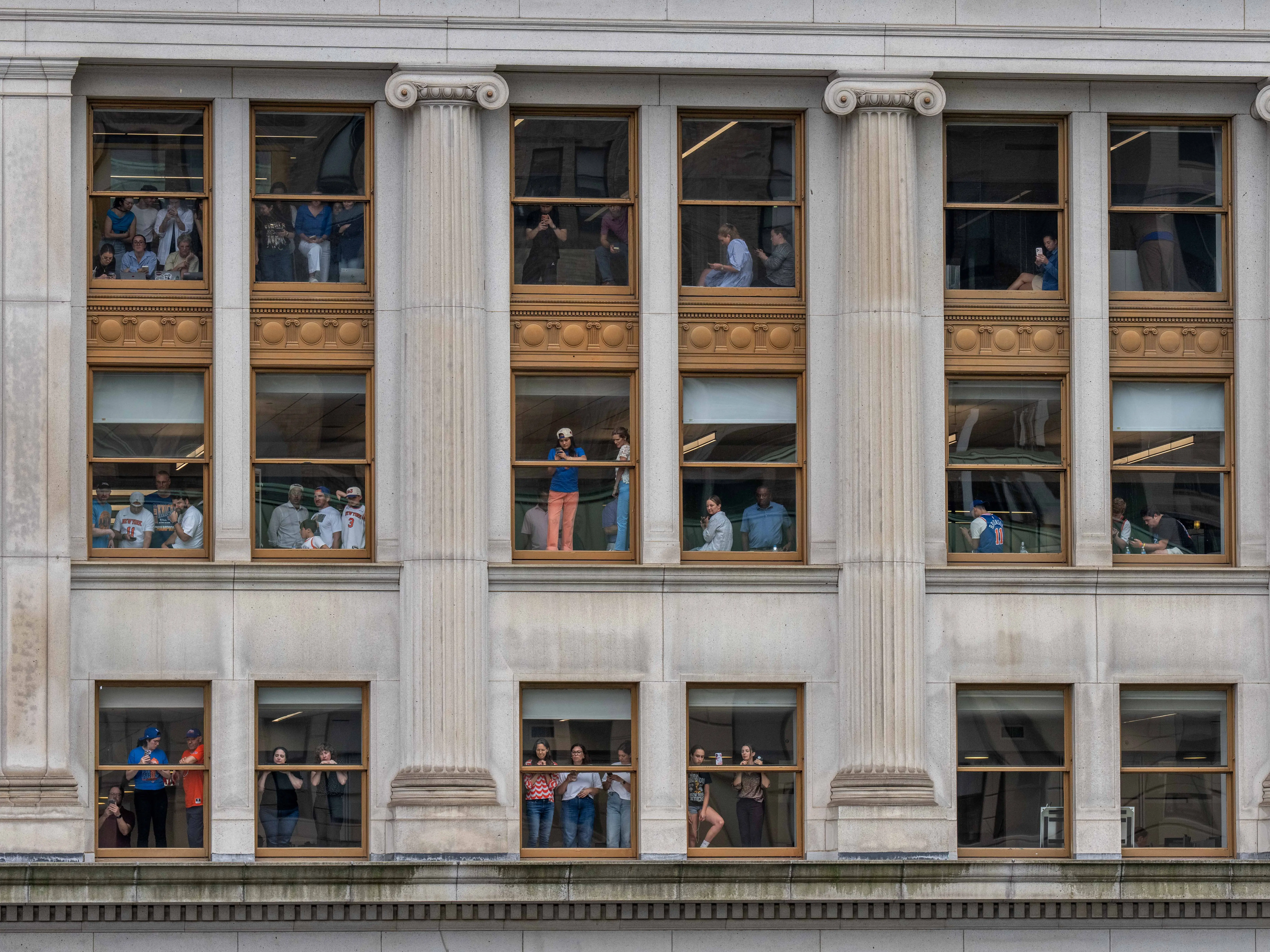People watch the knicks parade from office buildings