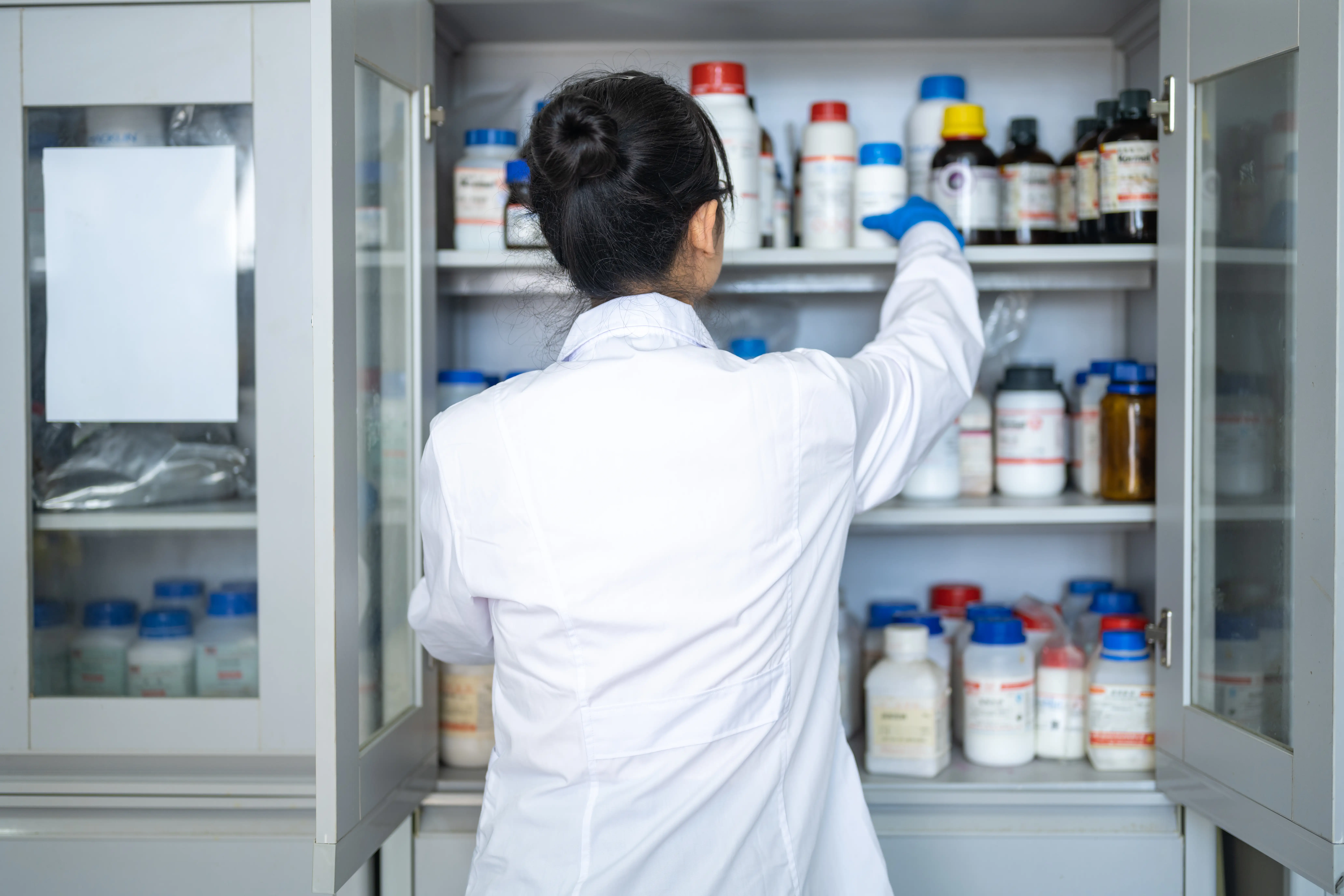 scientist pulling drugs out of cabinet