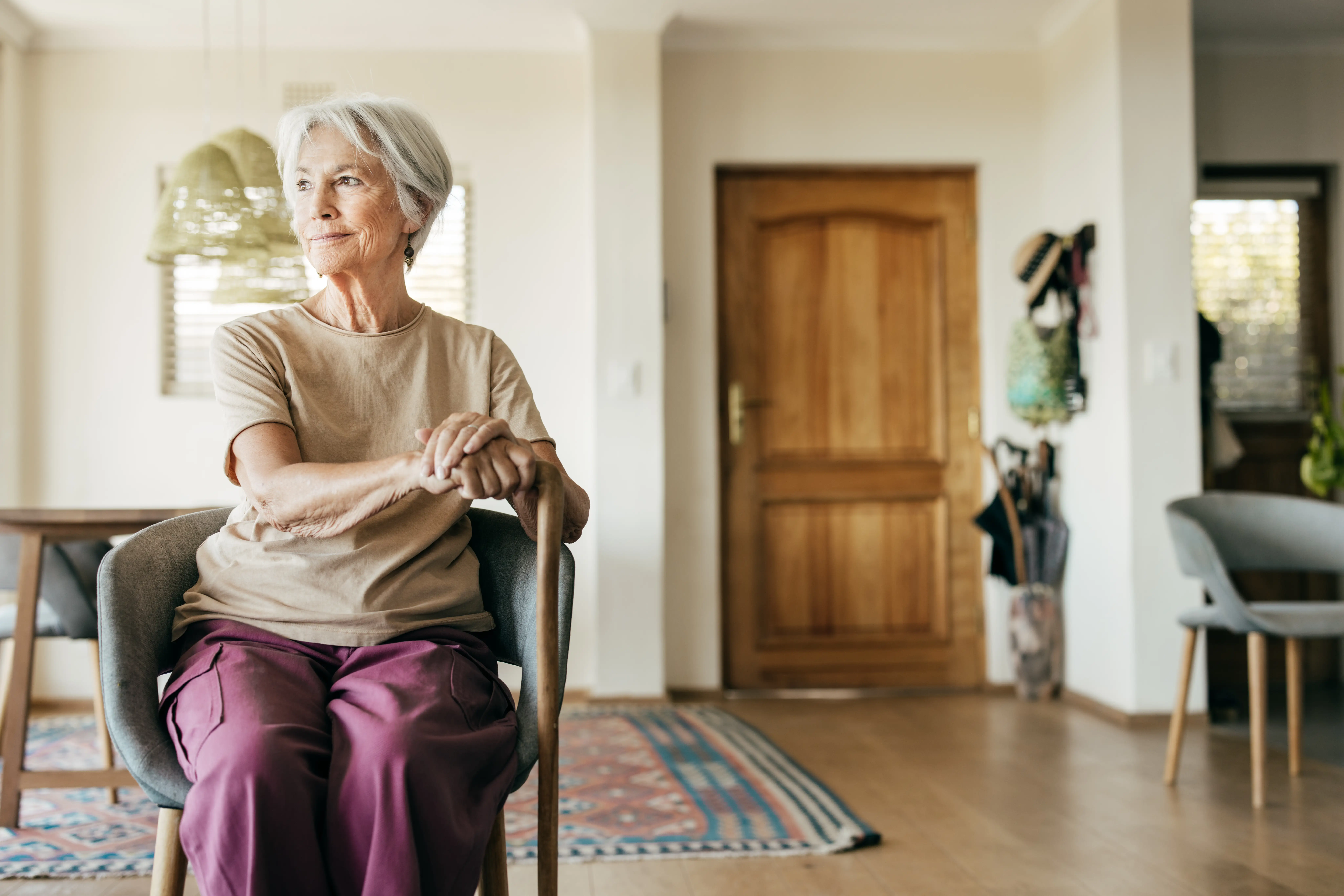 older person sitting with cane