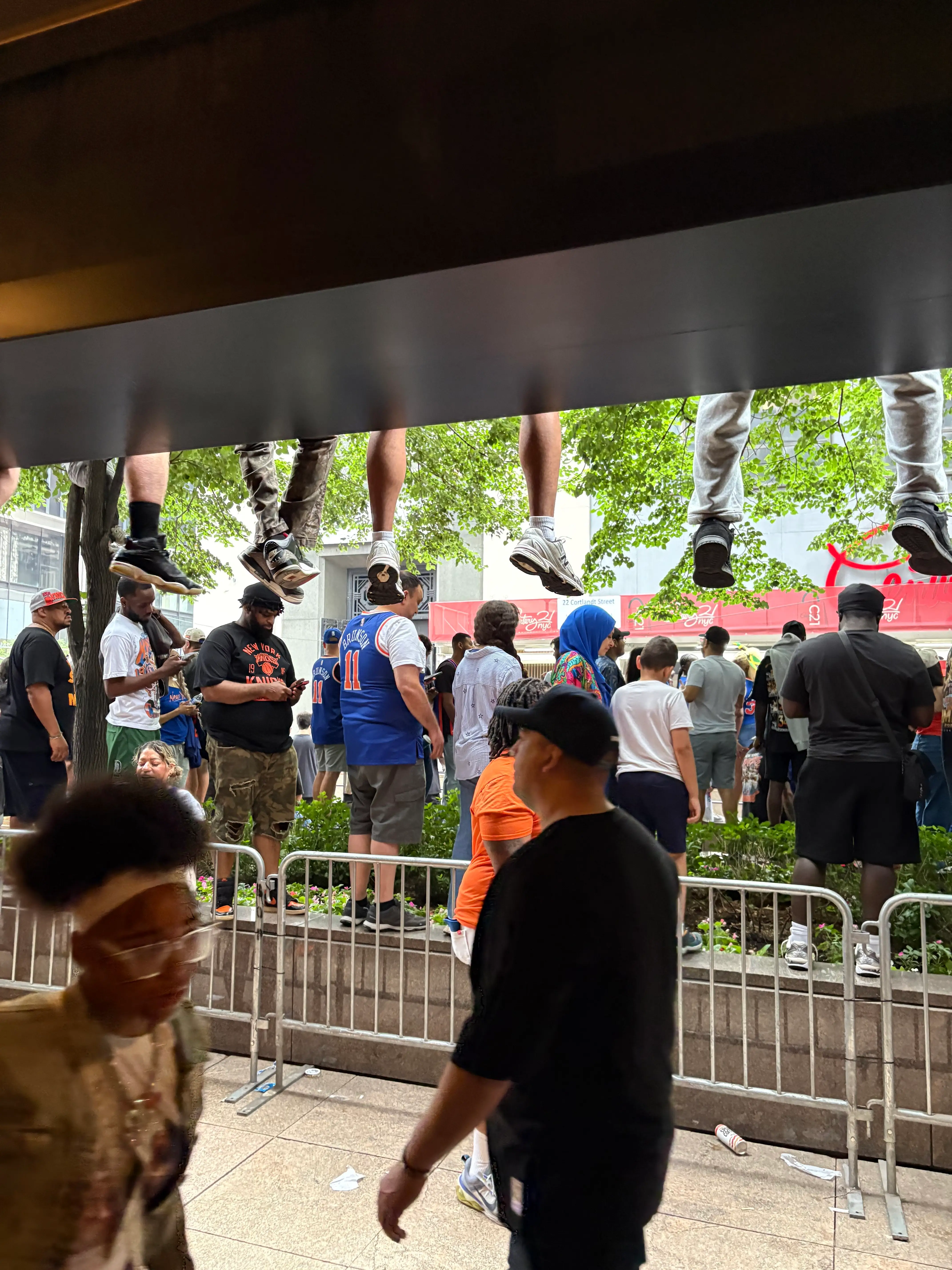 Onlookers for the Knicks parade sit with feet dangling from second floor.