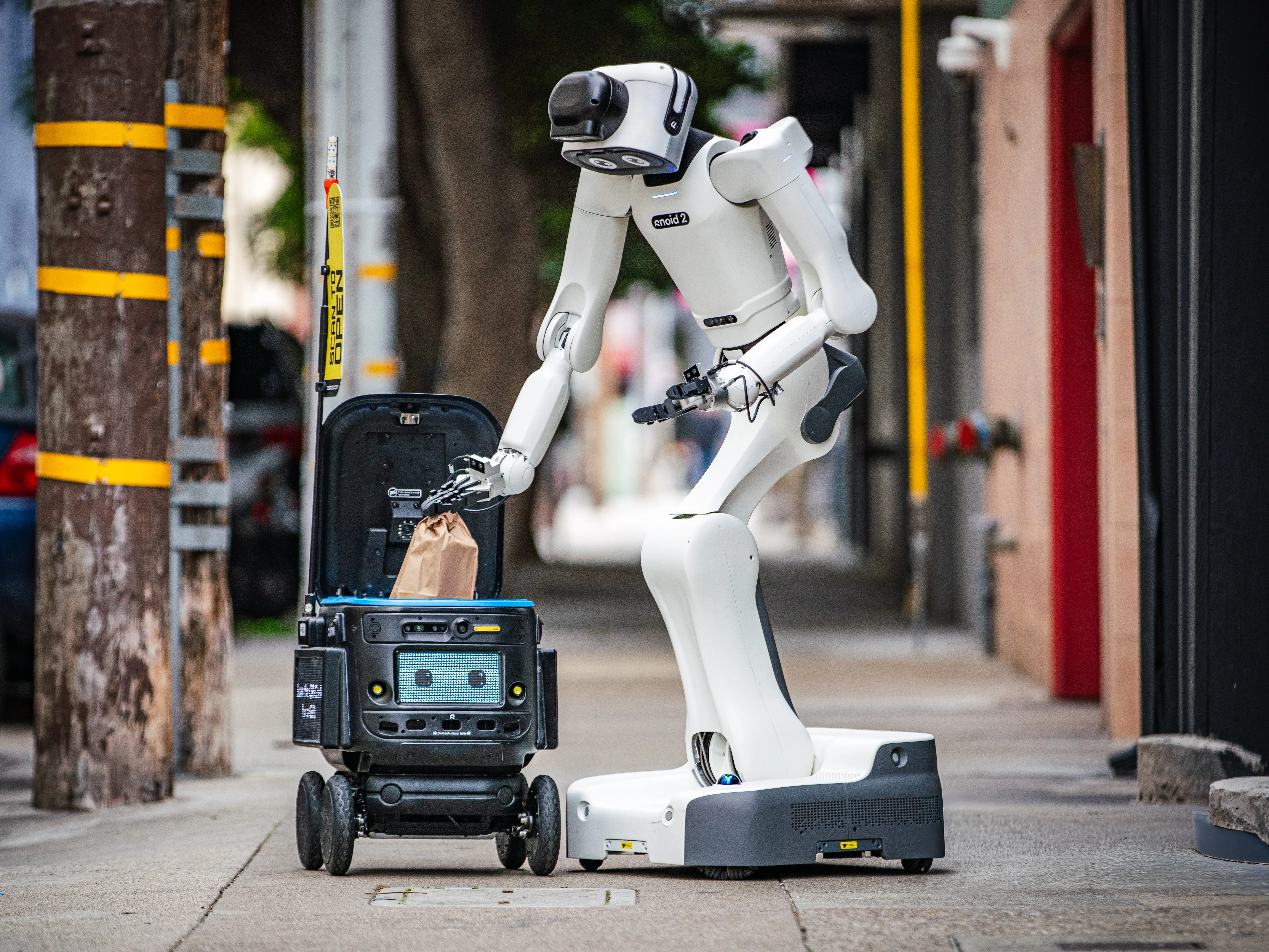 A delivery robot putting goods inside a delivery robot.