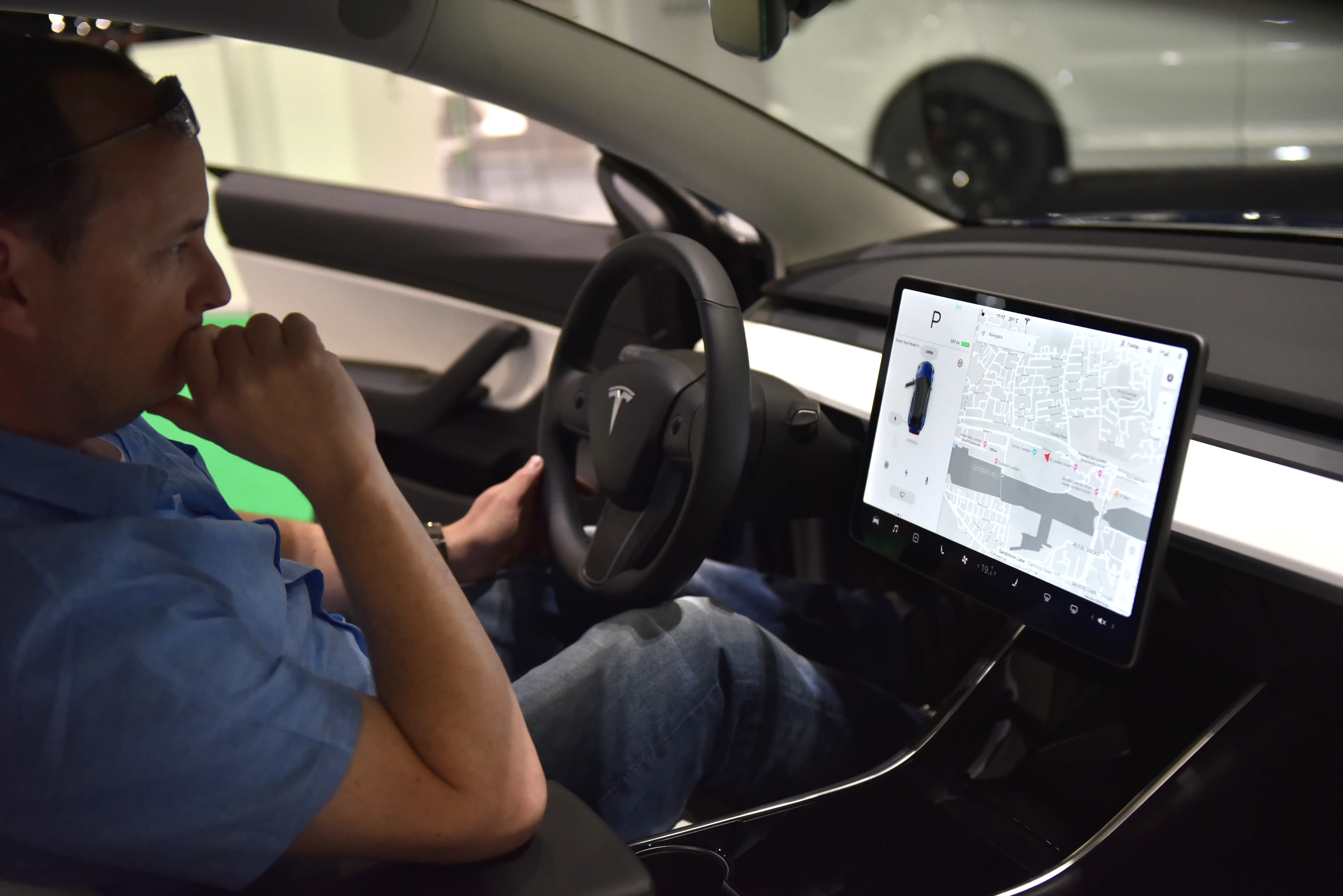 The interior showing the dashboard of a Tesla Model 3 is displayed.