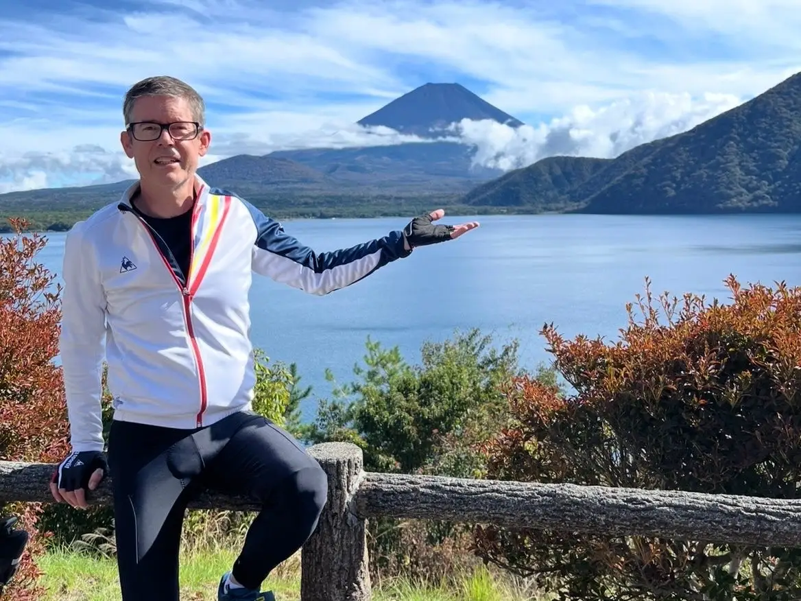 A man posing with Japan's Mount Fuji in the background.