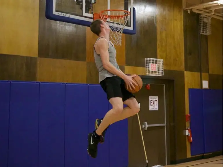 A man playing basketball and jumping in the air.
