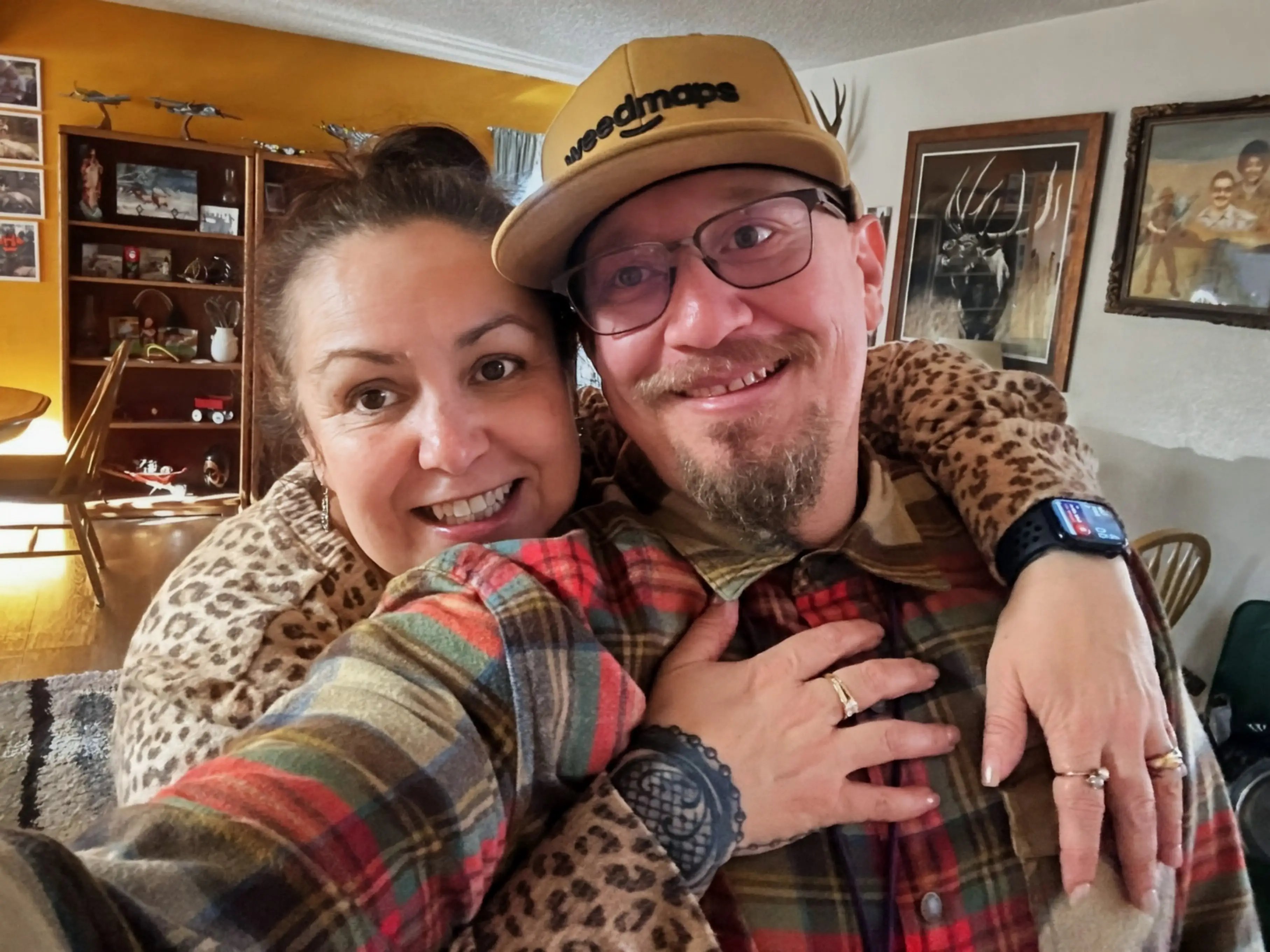 A couple taking a selfie in their home.