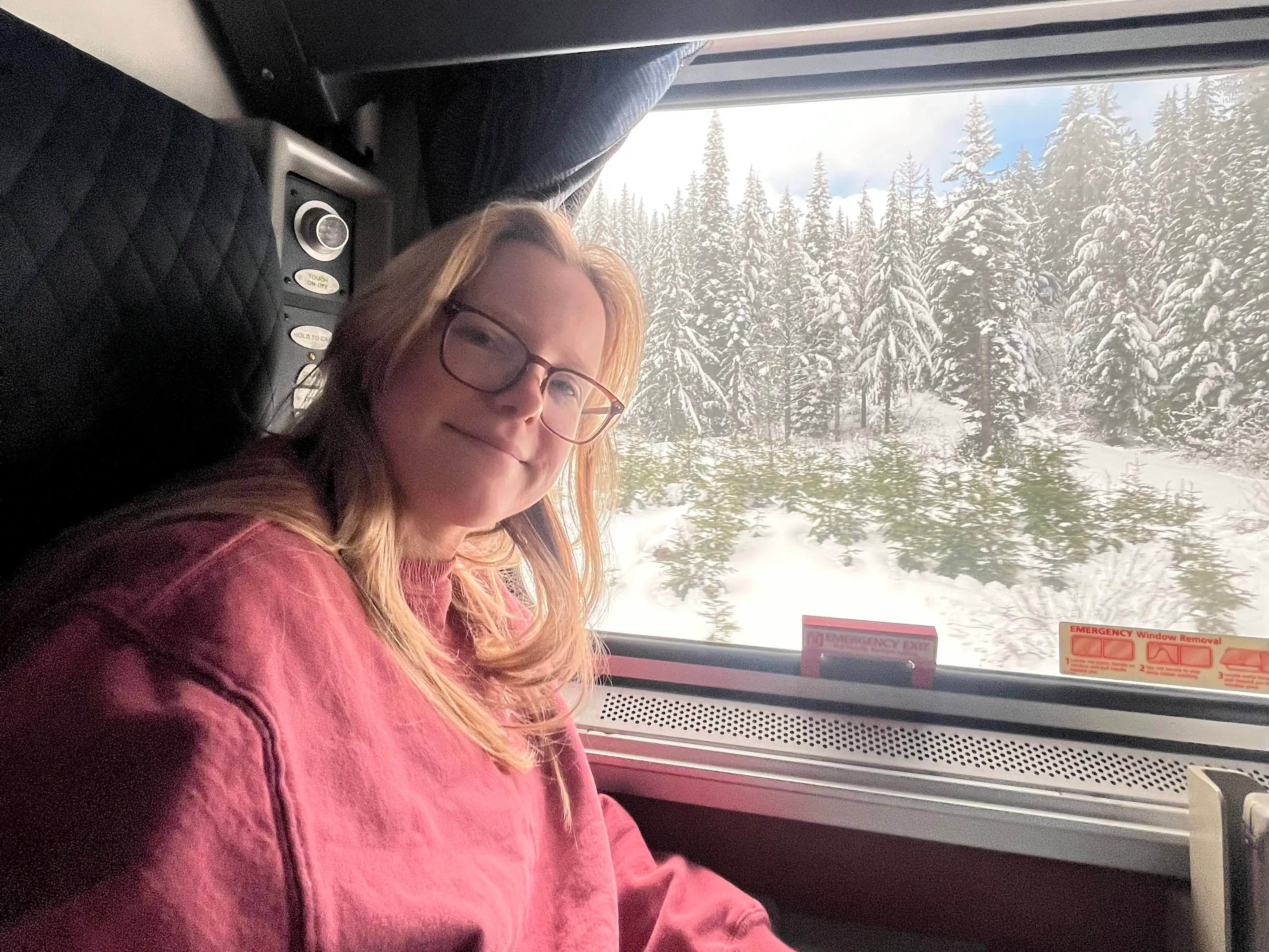 A woman sitting in a roomette on an Amtrak train.