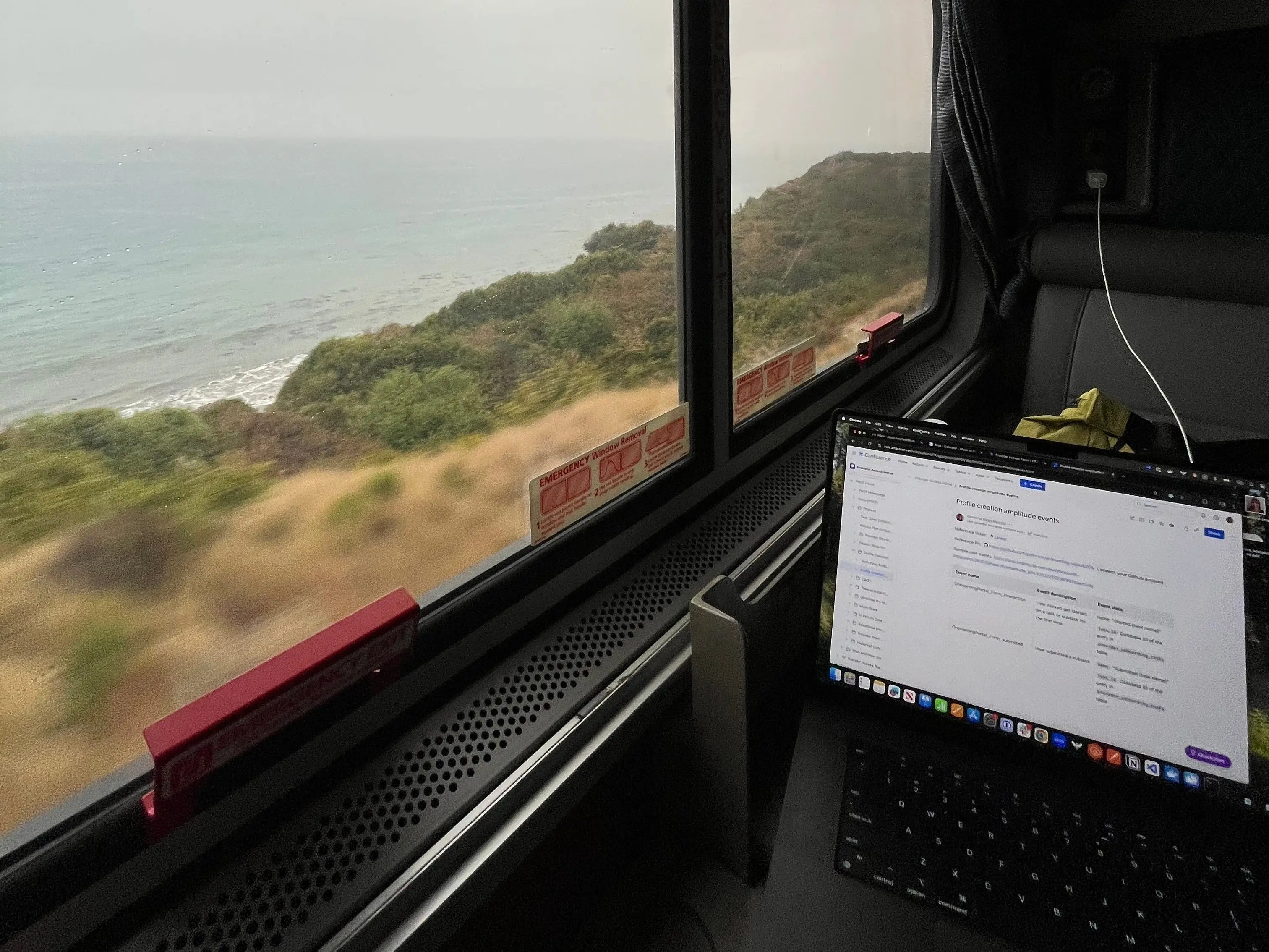 A laptop sitting near a window inside an Amtrak roomette.