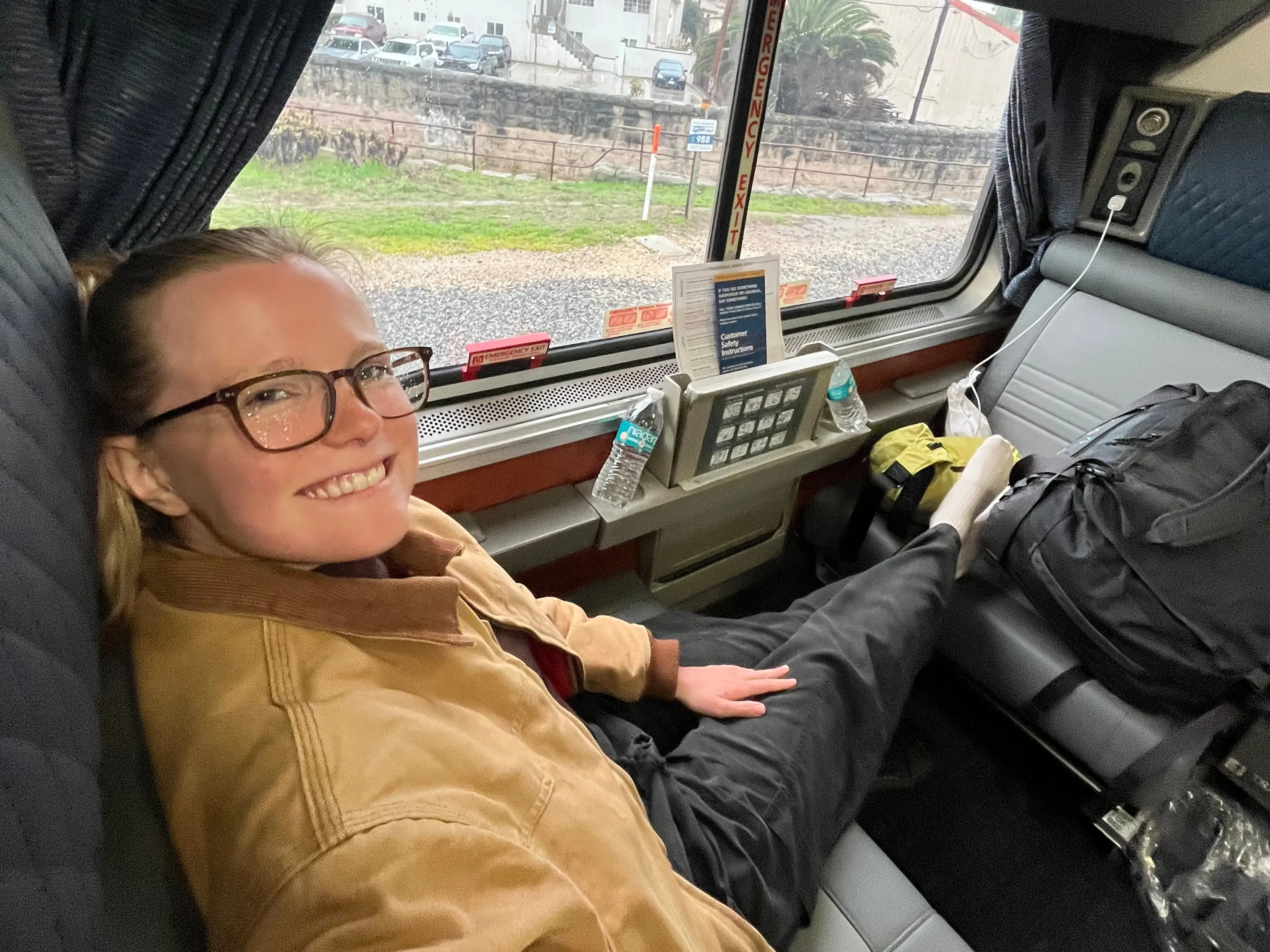 A woman sitting in a private roomette on an Amtrak train.