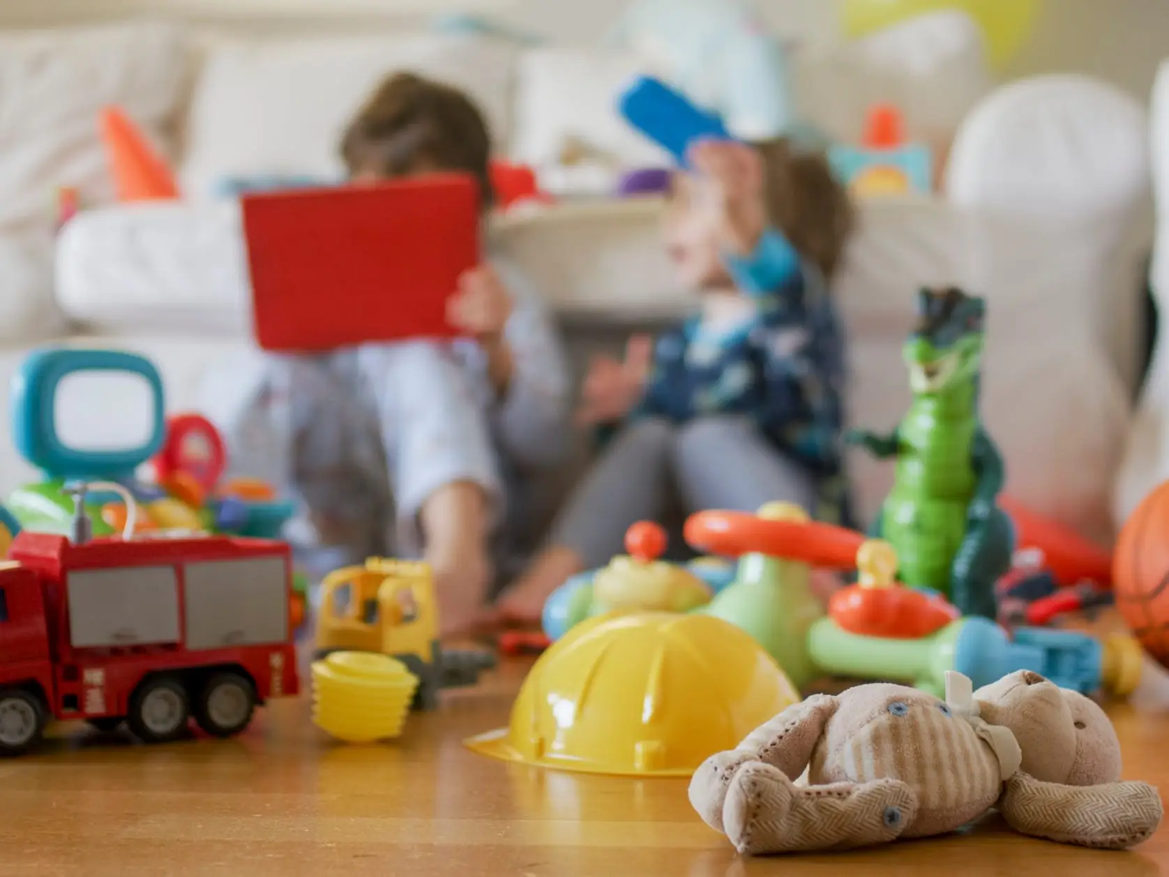 Kids playing on the floor with toys.
