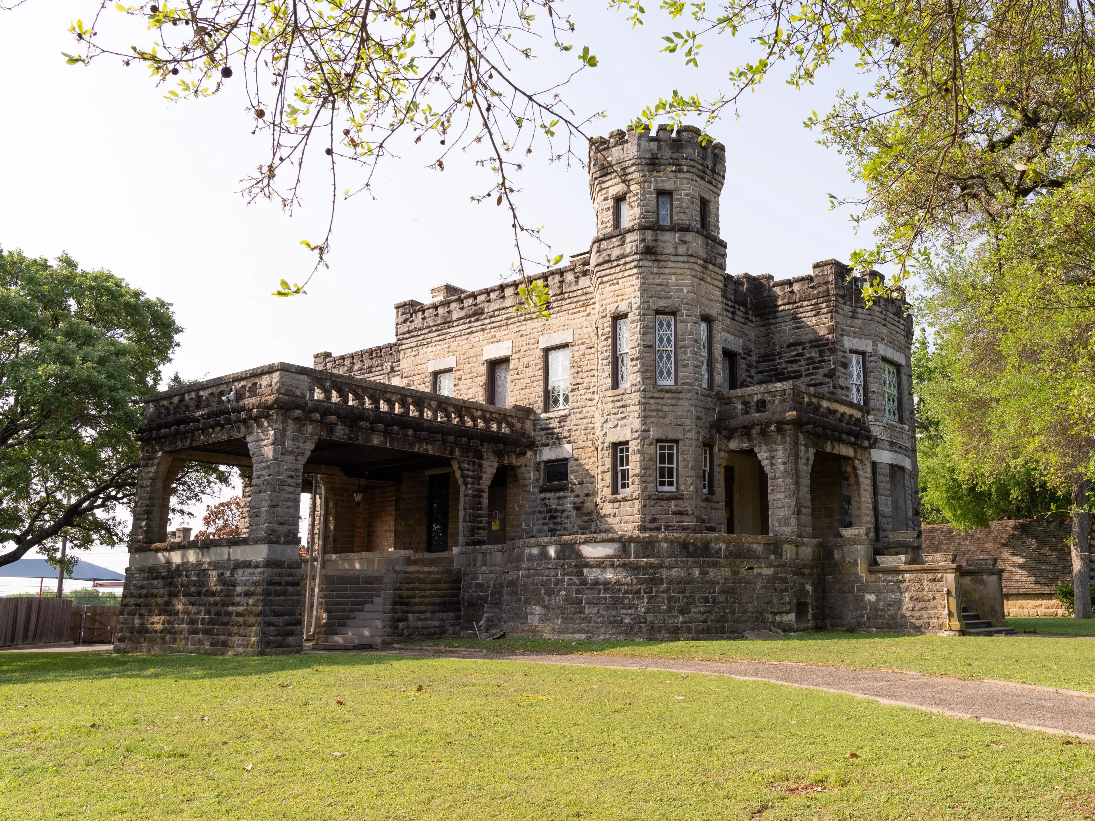 A photo of a castle with trees and grass around it.