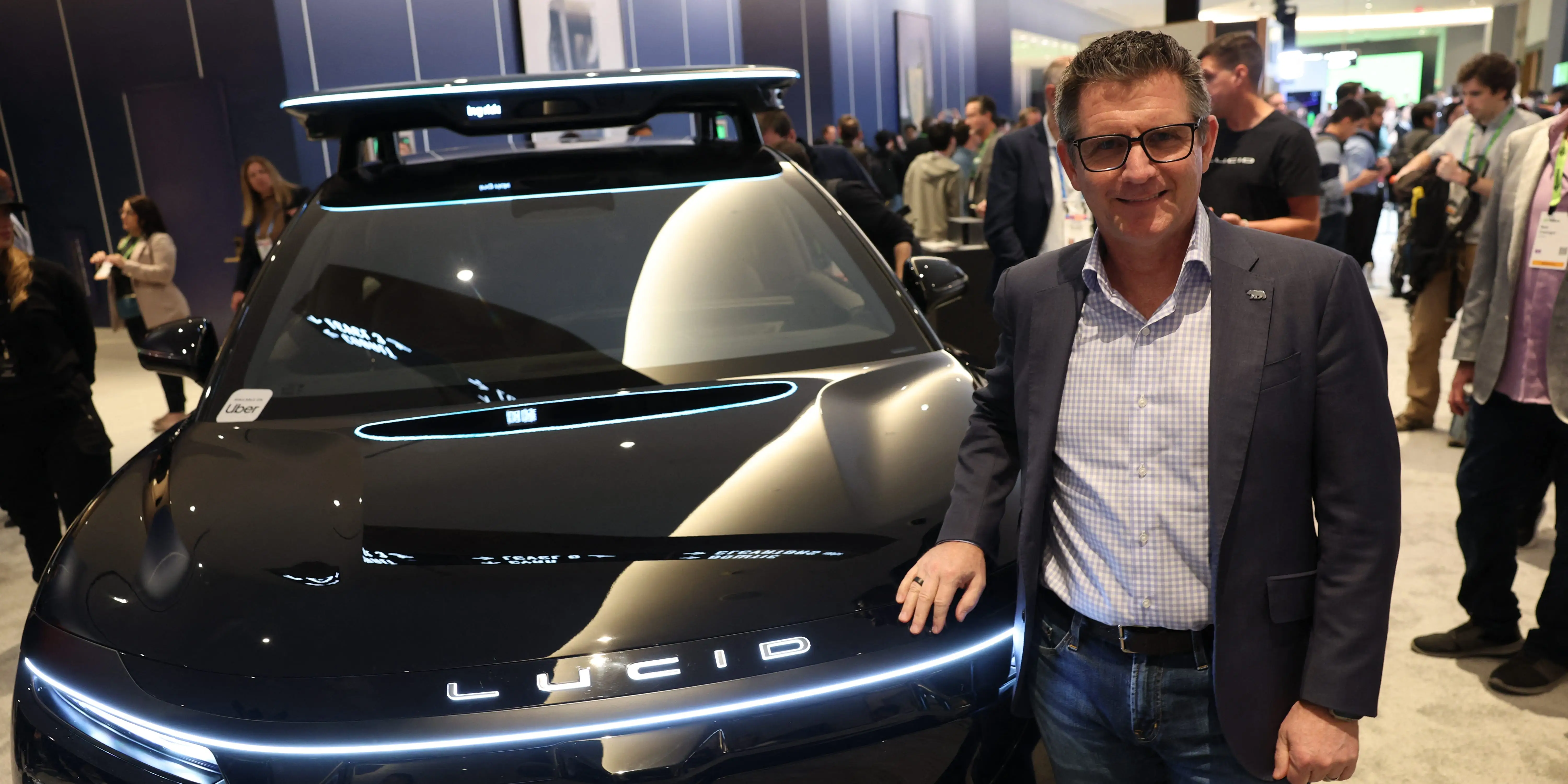Marc Winterhoff stands next to a Lucid Gravity robotaxi.