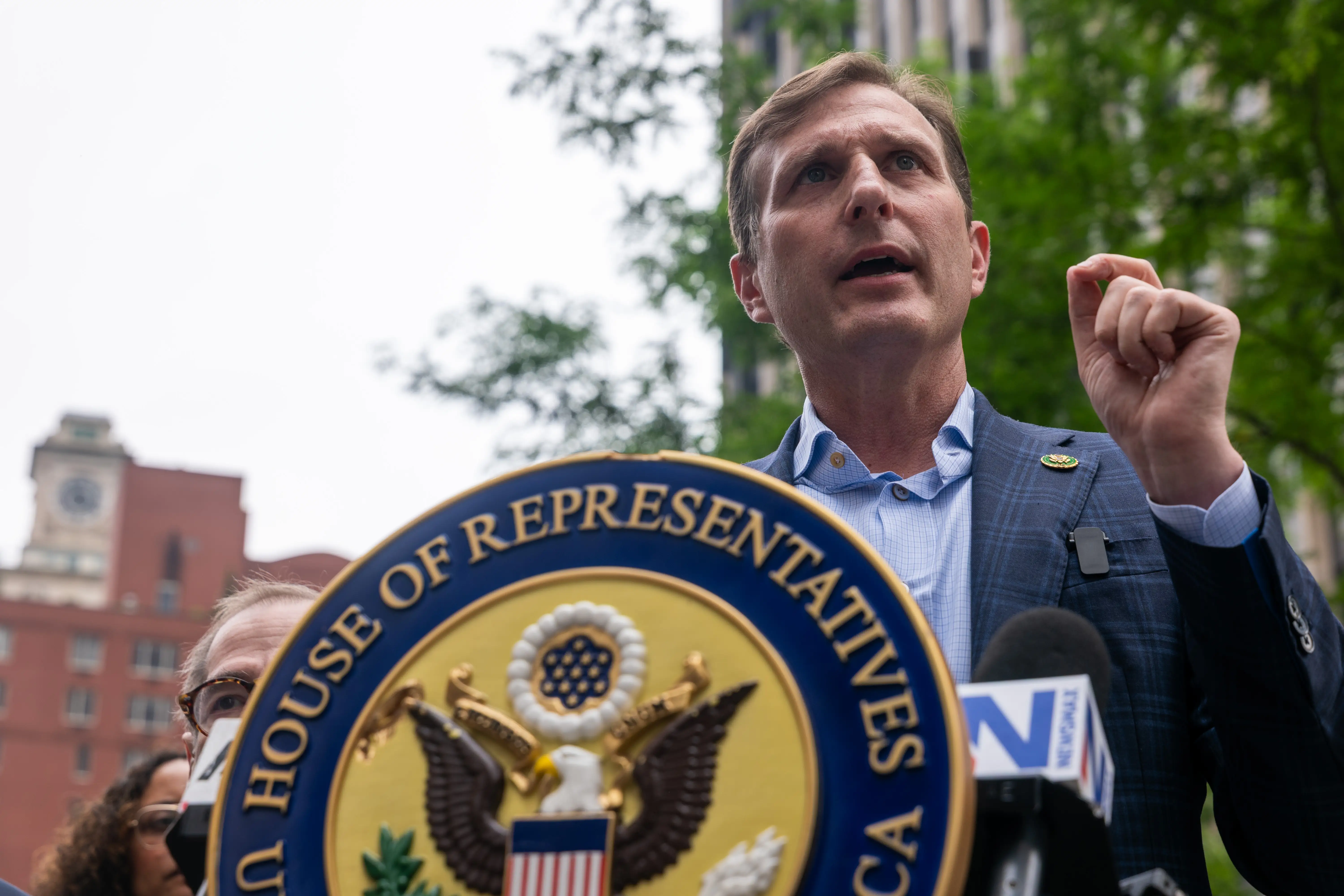 Rep. Dan Goldman speaks in front of a microphone